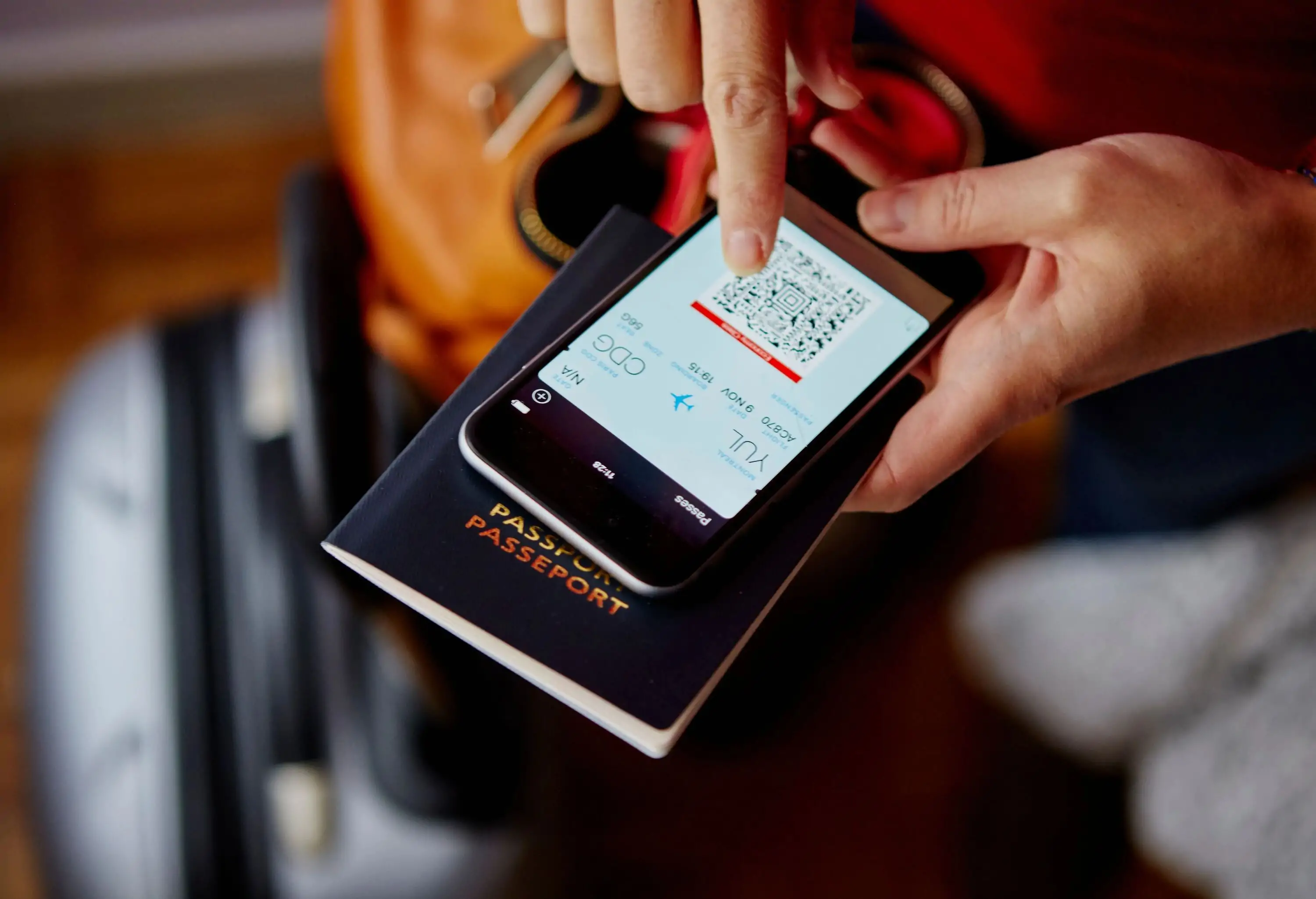 Close up of hands holding a passport and smartphone with boarding pass