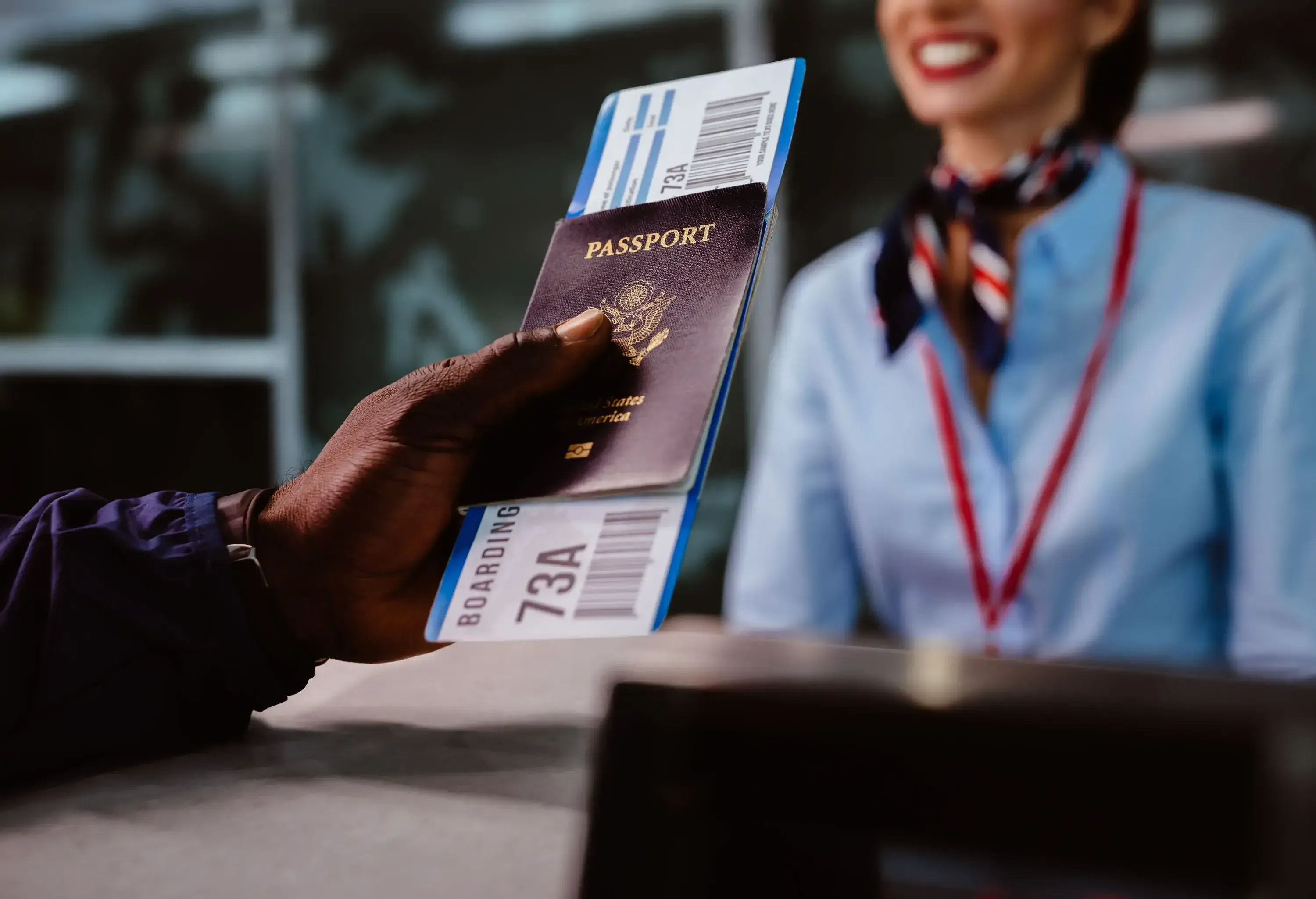 African American man holding boarding pass and passport at airline check-in desk at international airport