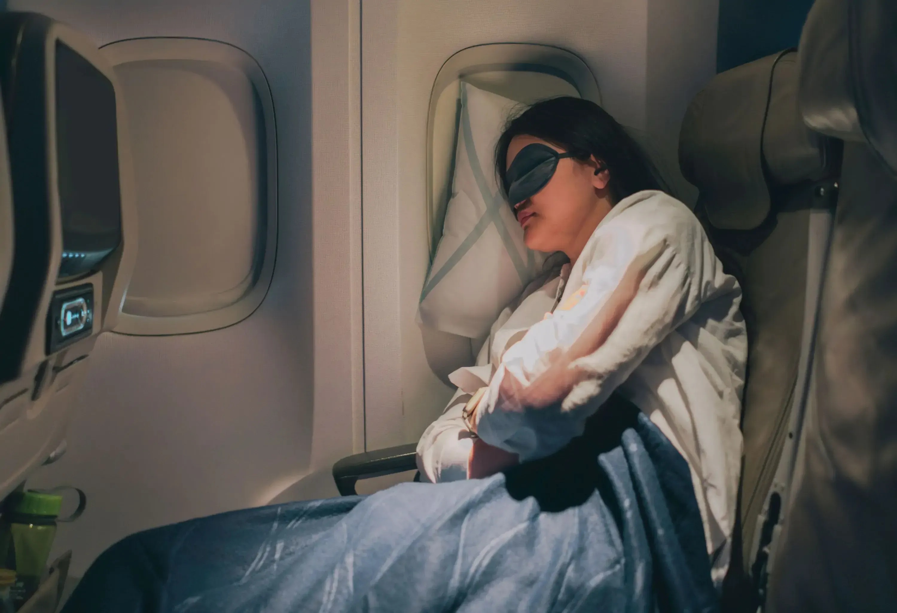 With her mask on to help her sleep, the woman gets good, deep sleep during her flight.