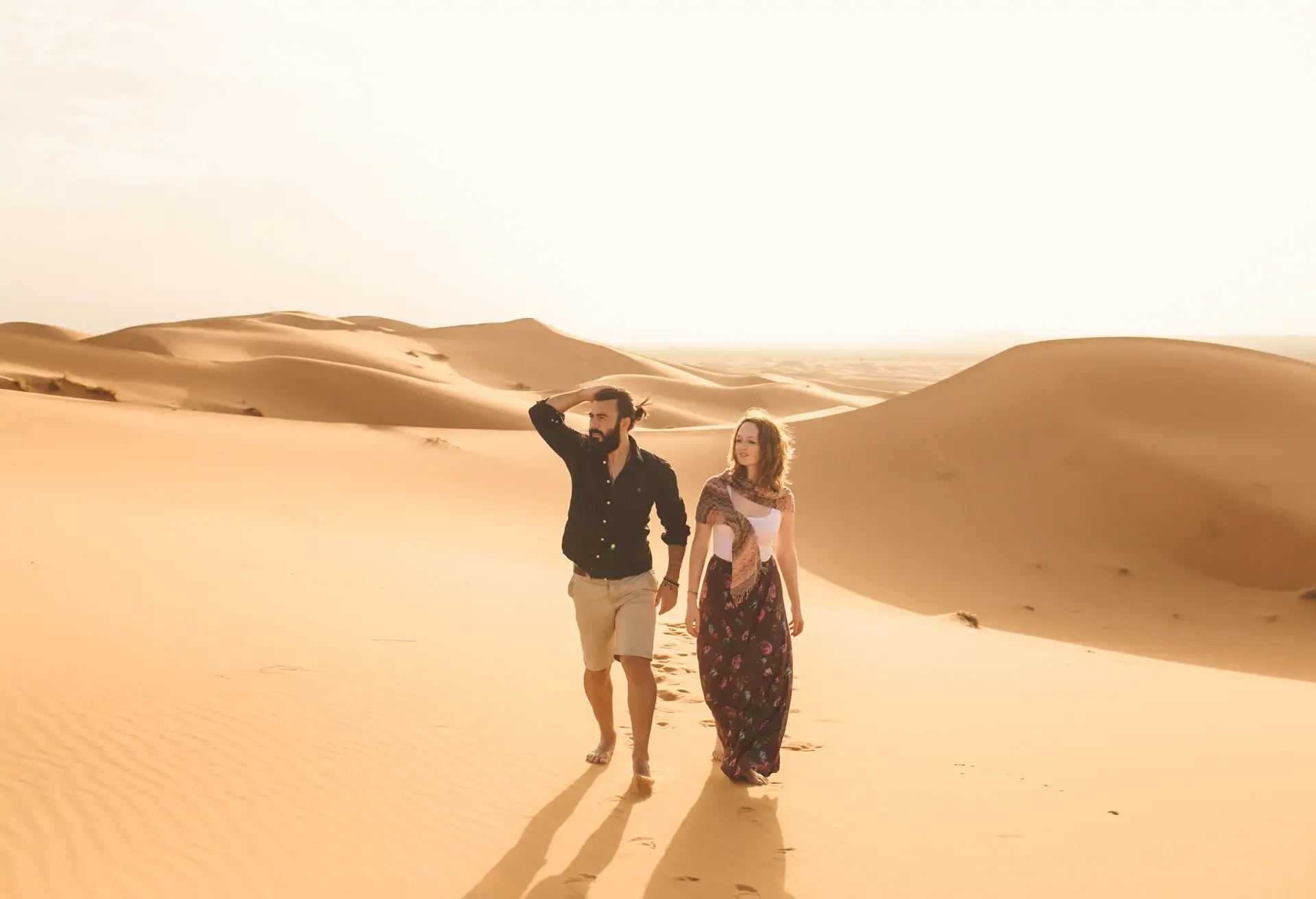 People Walking On Sand Dune Against Clear Sky