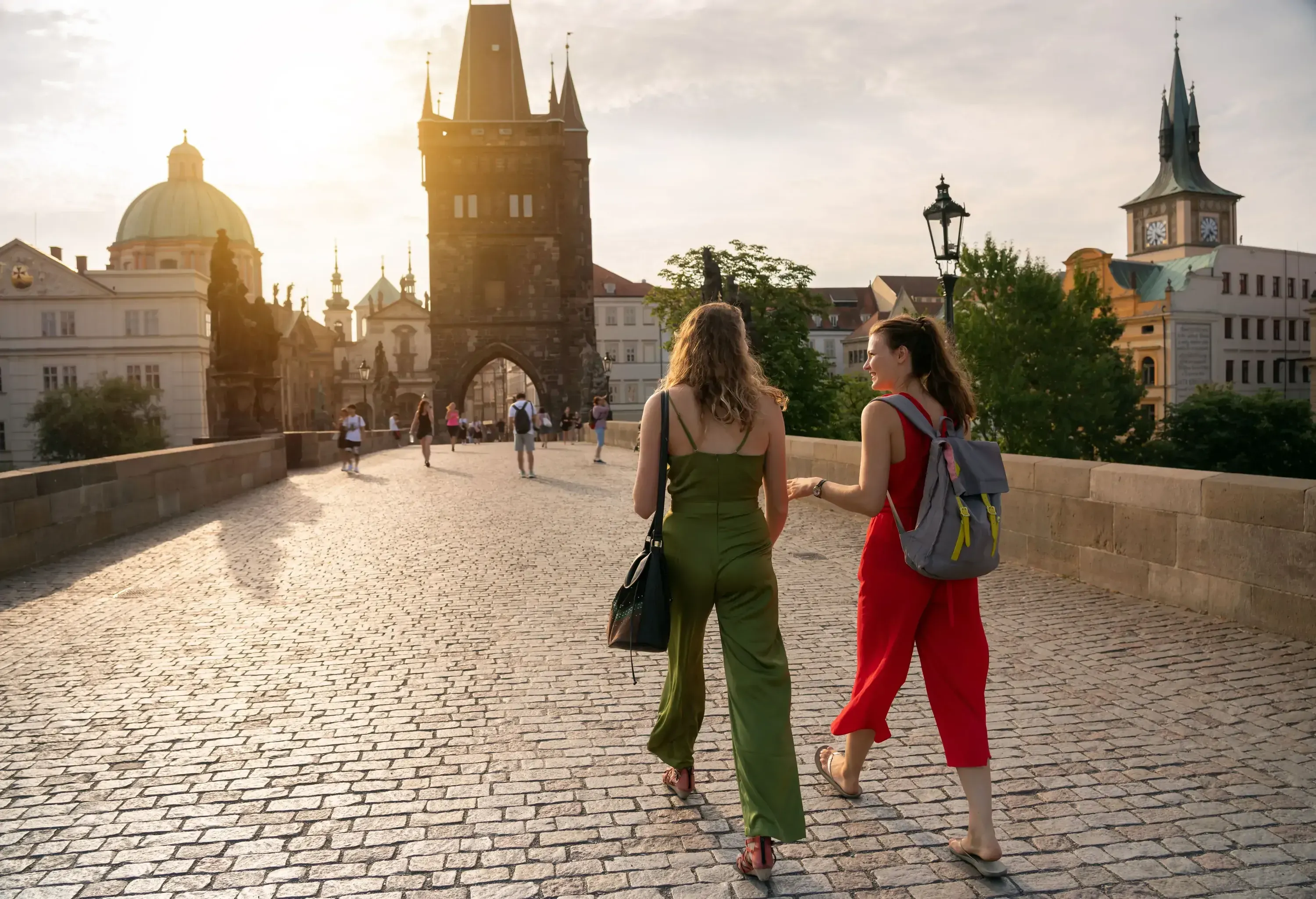 Female friends on holiday walking on Charles Bridge in Prague