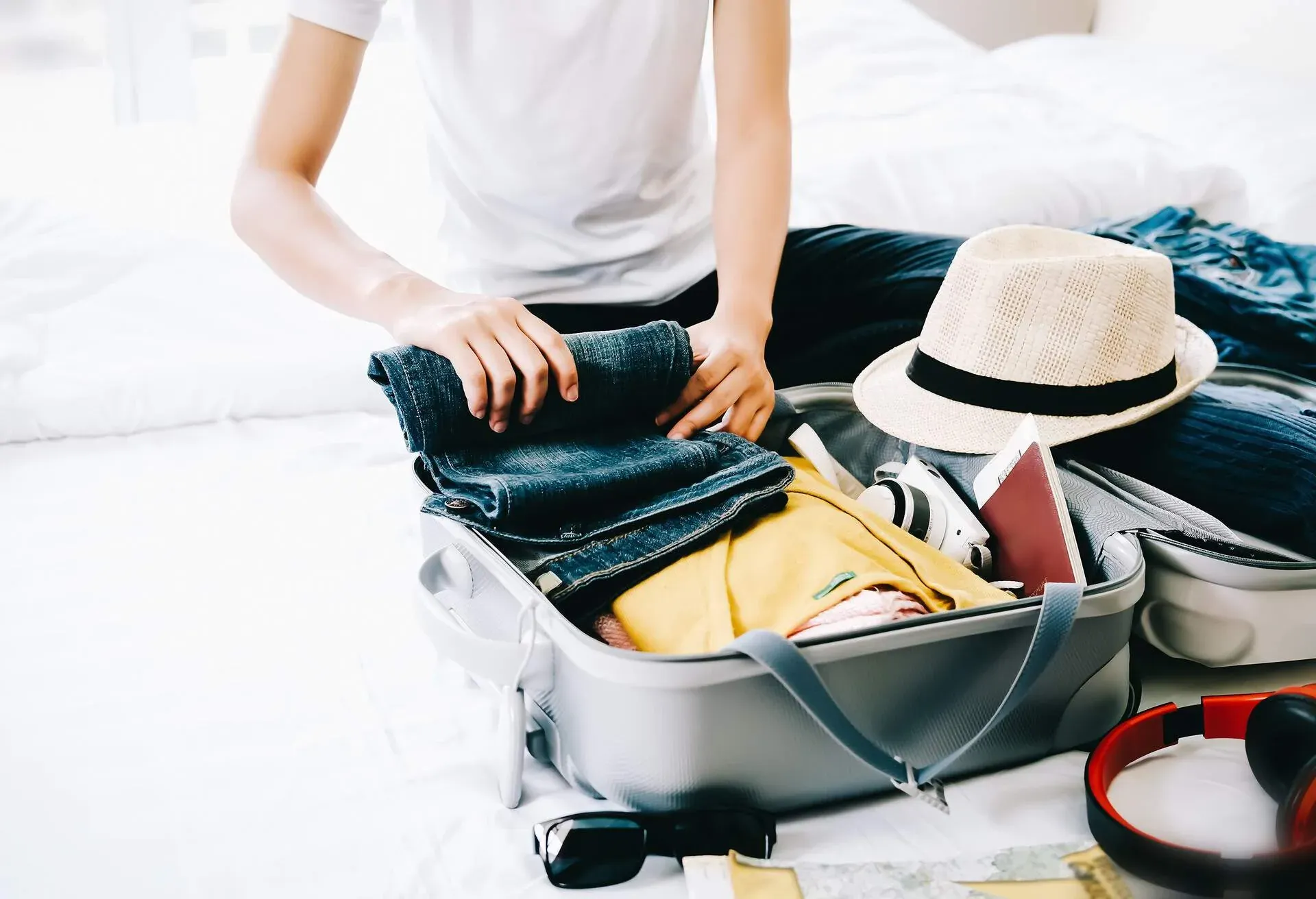 Woman packing travel bag for summer vacation. Tourism and objects concept, suitcase for summer holidays