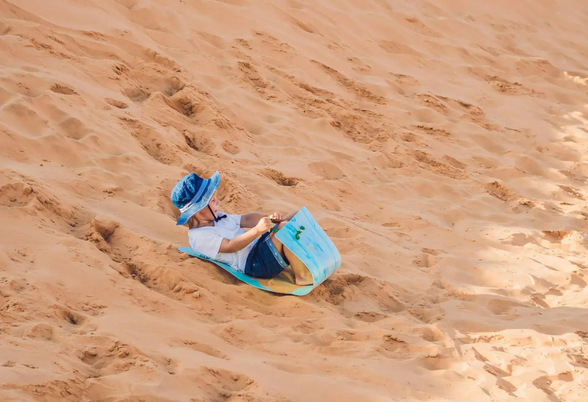 The boy runs around the red desert at dawn. Traveling in a fuss with children concept.