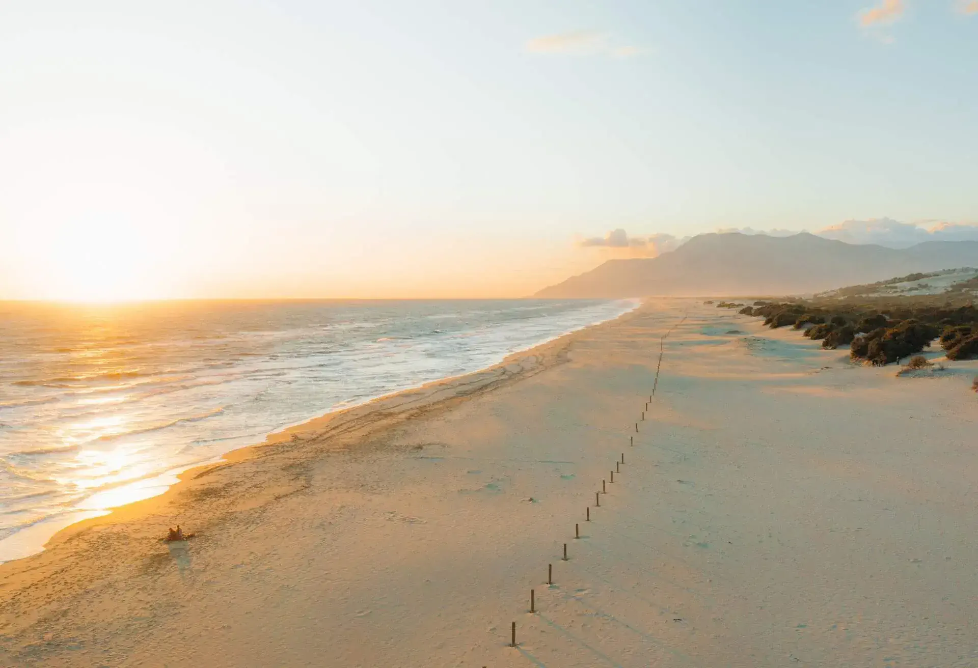 Drone panoramic photo of sand dune beach and the waved sea during bright colorful sunset at Patara, South Turkey