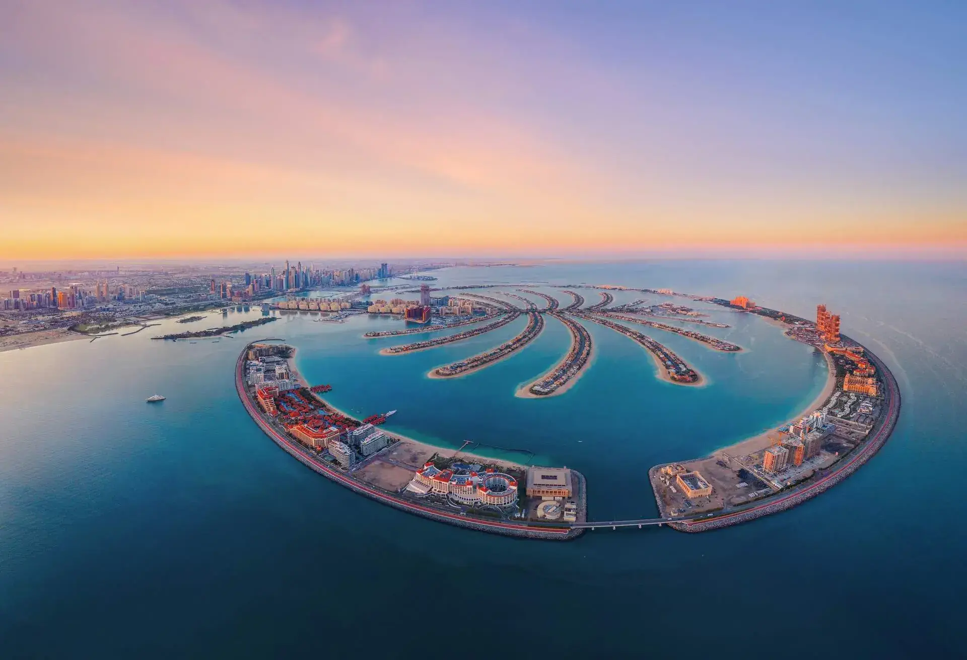 Aerial view of The Palm Jumeirah Island, Dubai Downtown skyline, United Arab Emirates or UAE. Financial district and business area in smart urban city. Skyscraper and high-rise buildings at sunset.