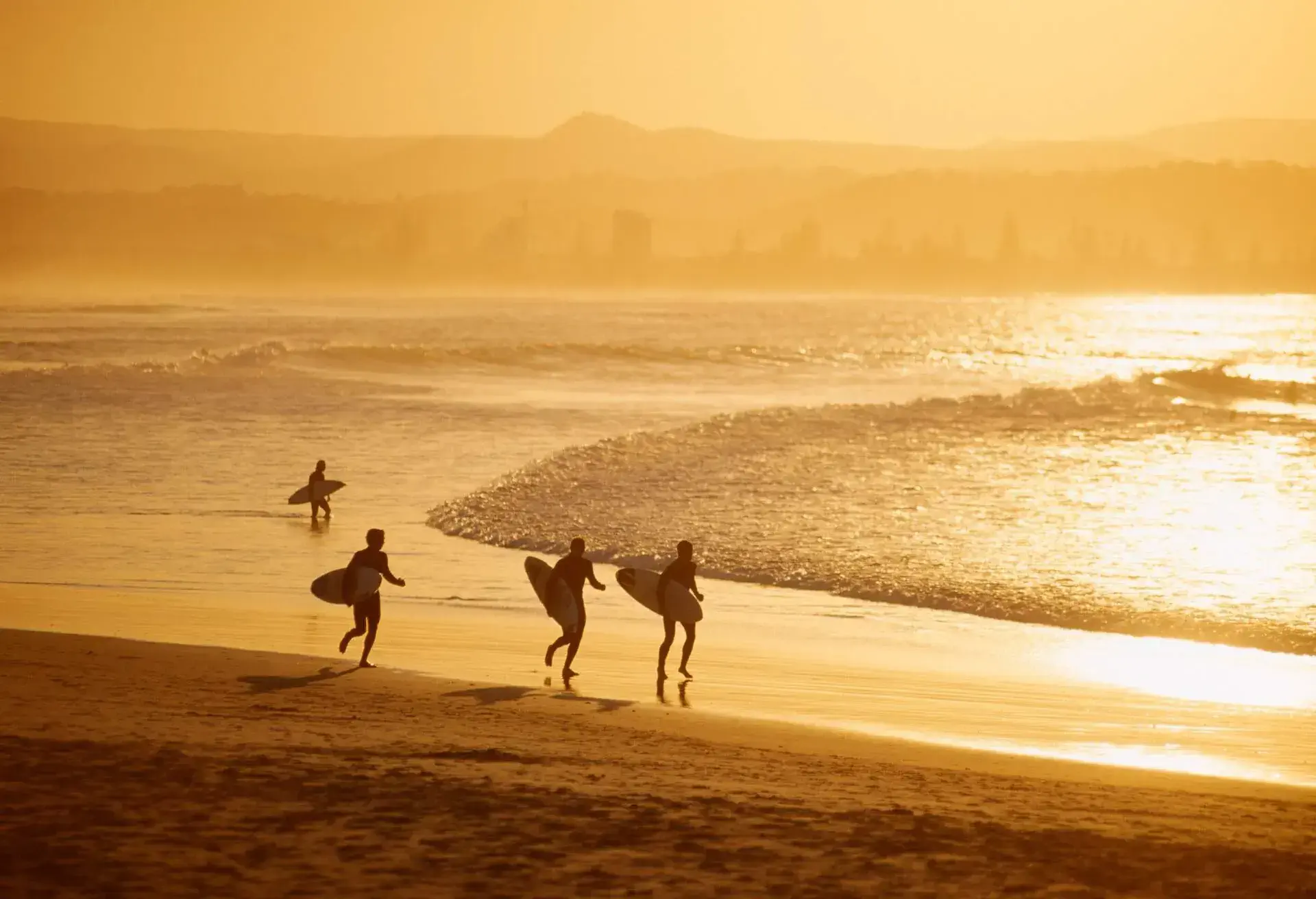Surfer walking on beach, Surfer's paradise.