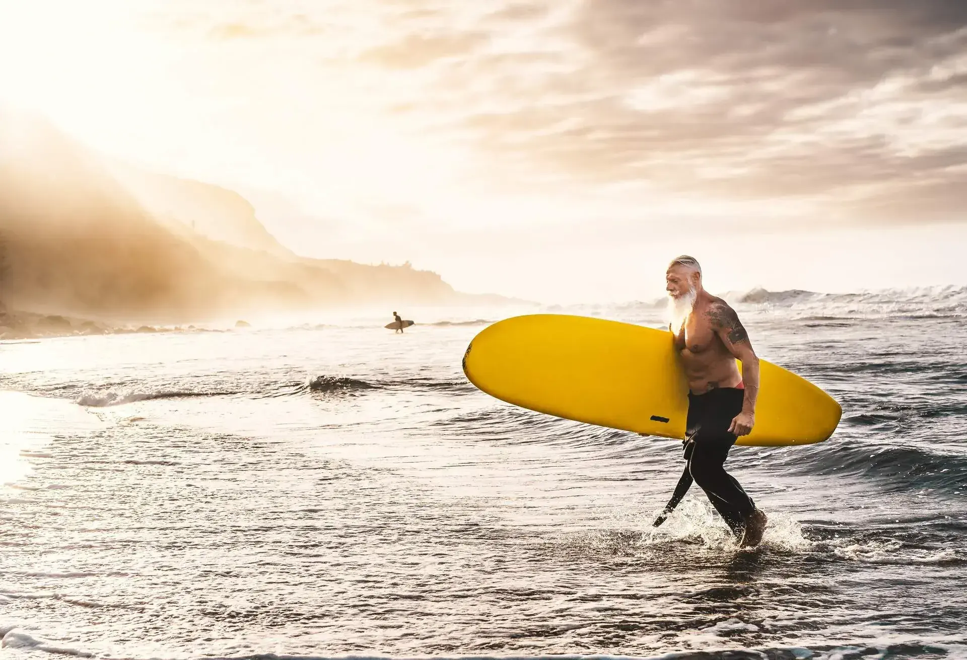 person_surfing_beach_ocean_senior_tattoos-shutterstock-portfolio