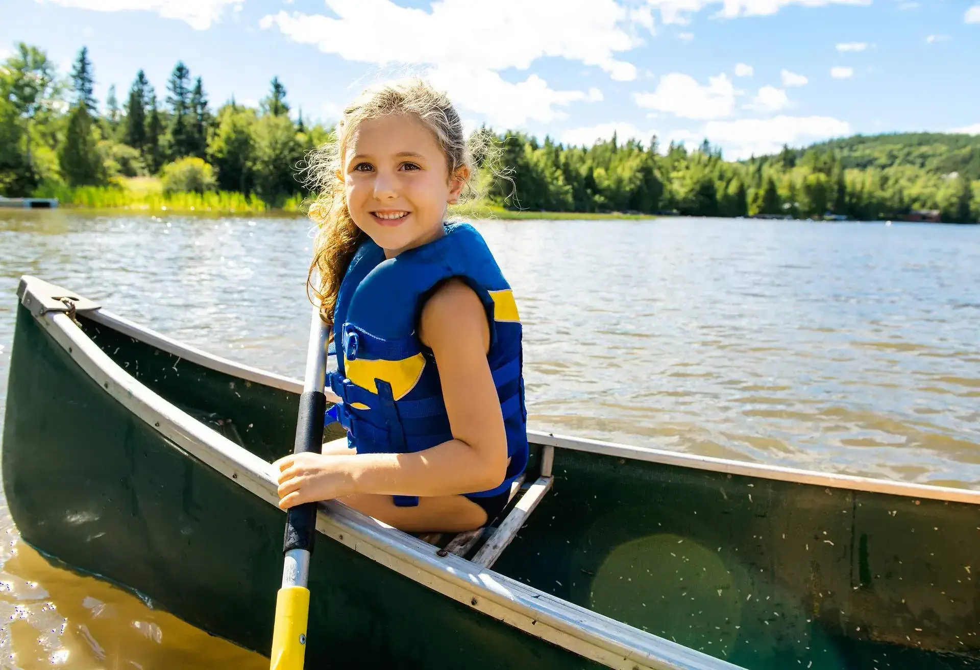 A Happy kid enjoying canoe ride on beautiful river