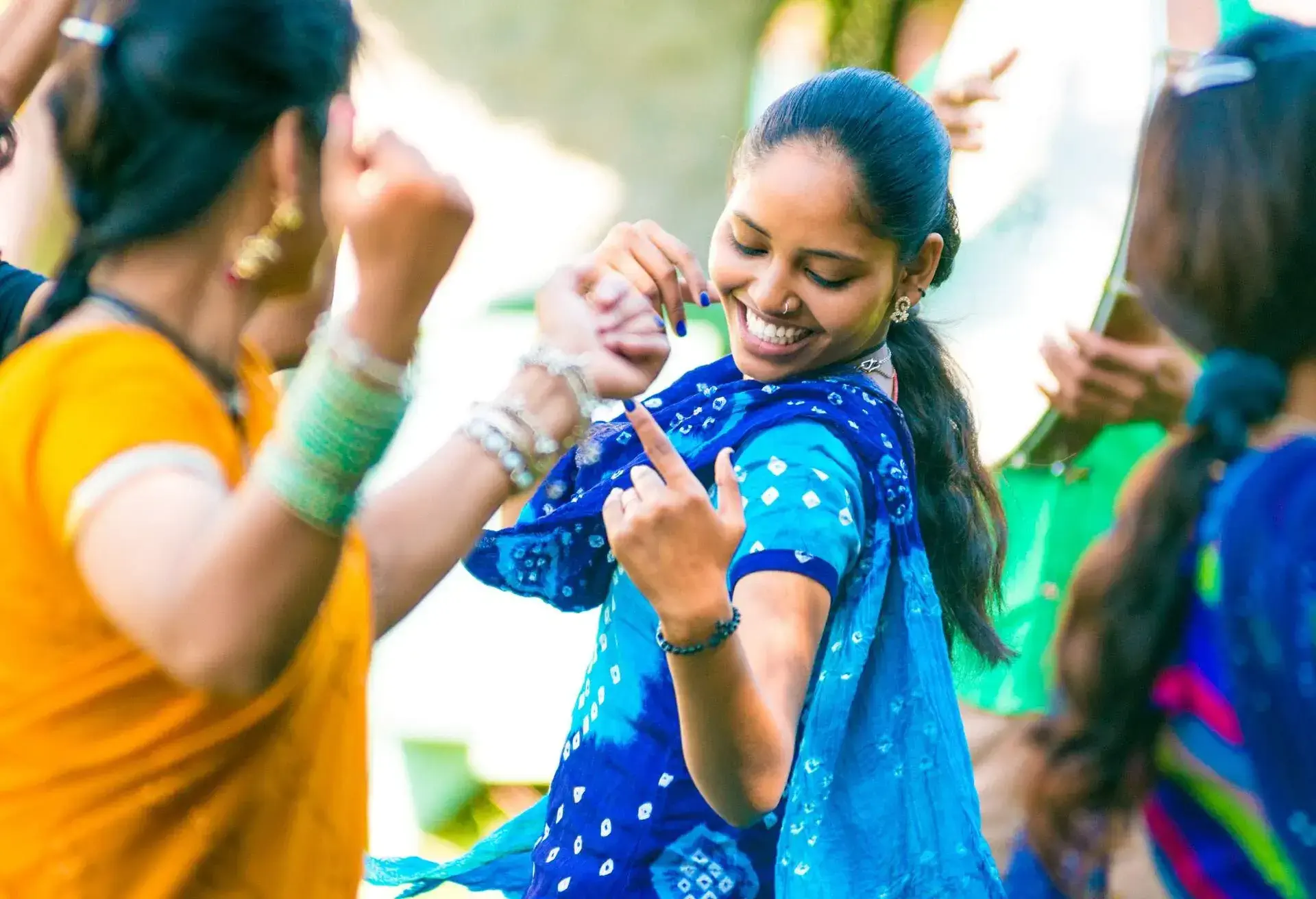 Young indian woman dancing with friends