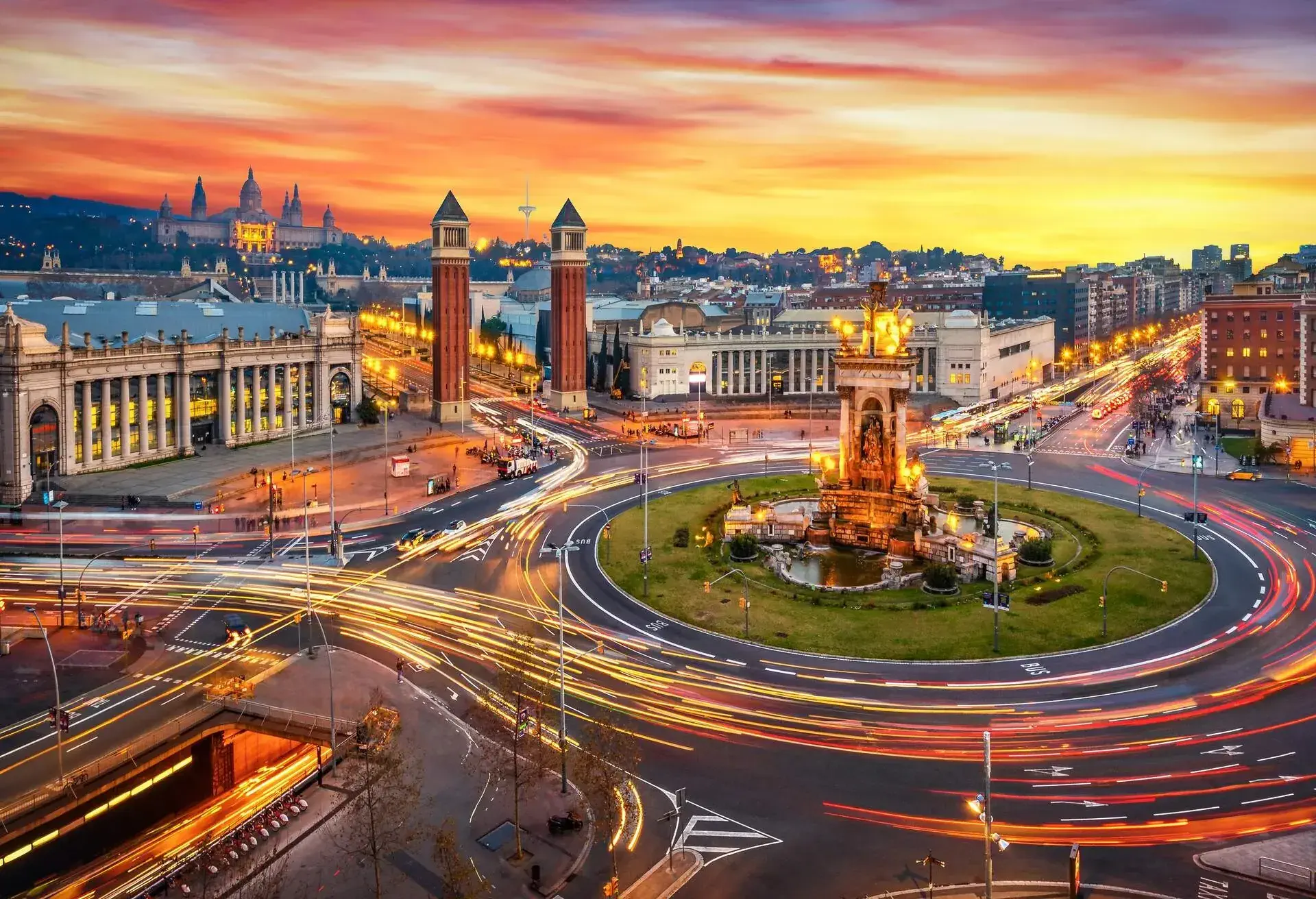 Long exposure photo of Fira de Barcelona, Plaça d'espanya (Spain square) and montjuic mountain in Barcelona at sunset with car light trails . Spain