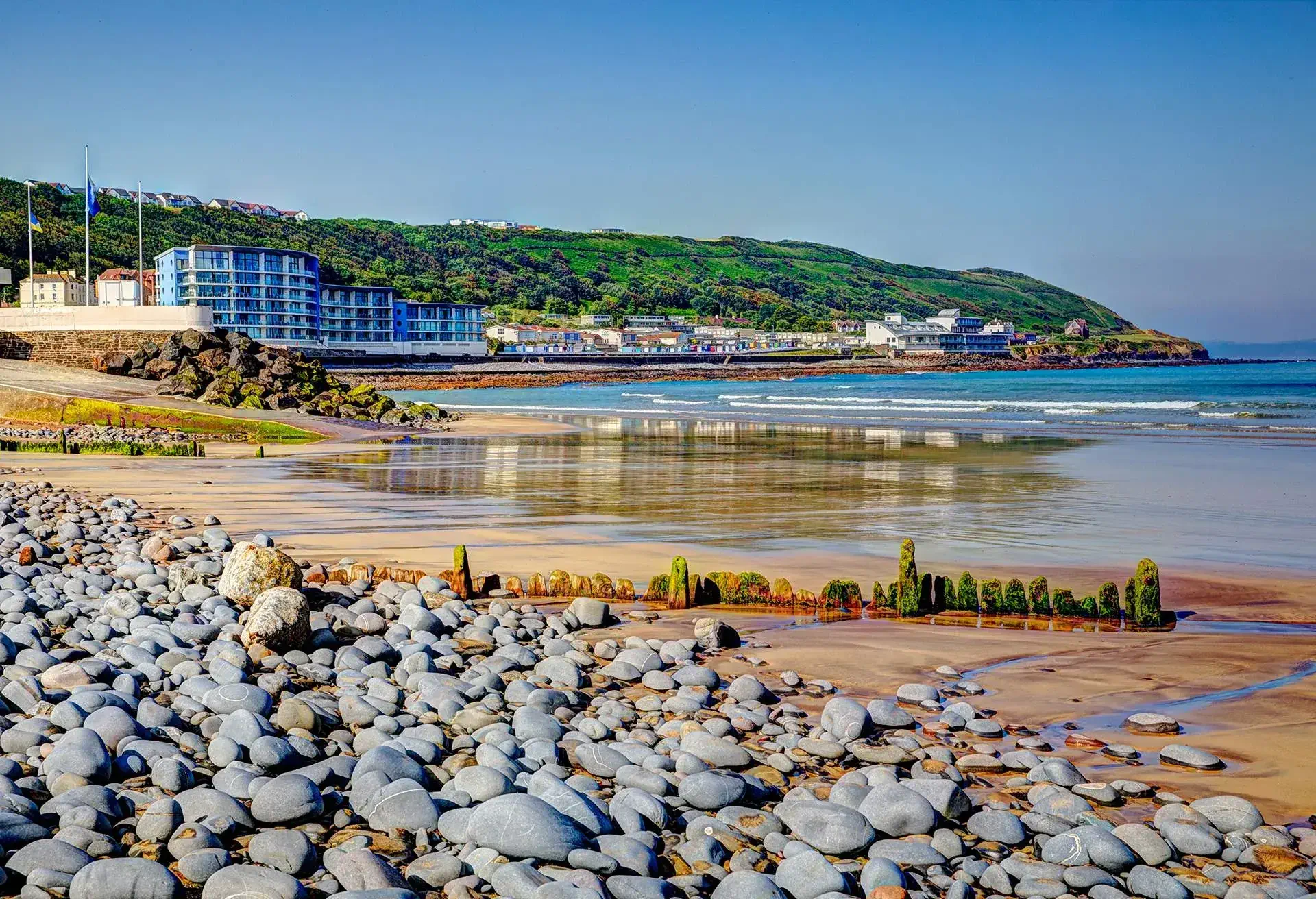 View of pebbles and beach with buildings in the background