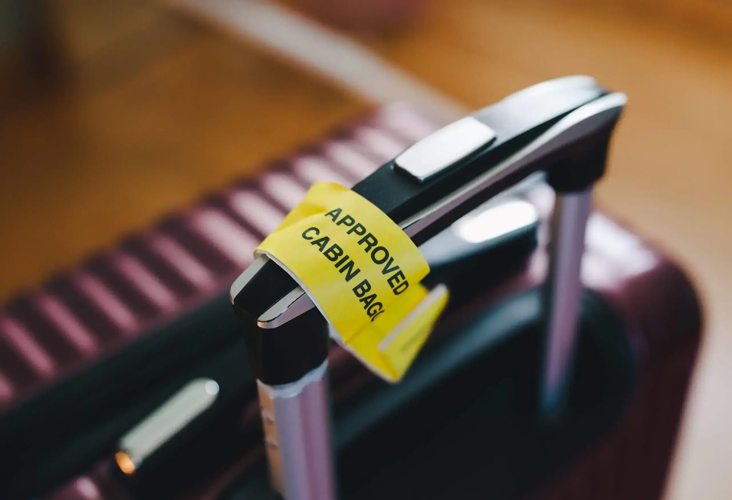 A purple suitcase with a baggage tag affixed to the handle.