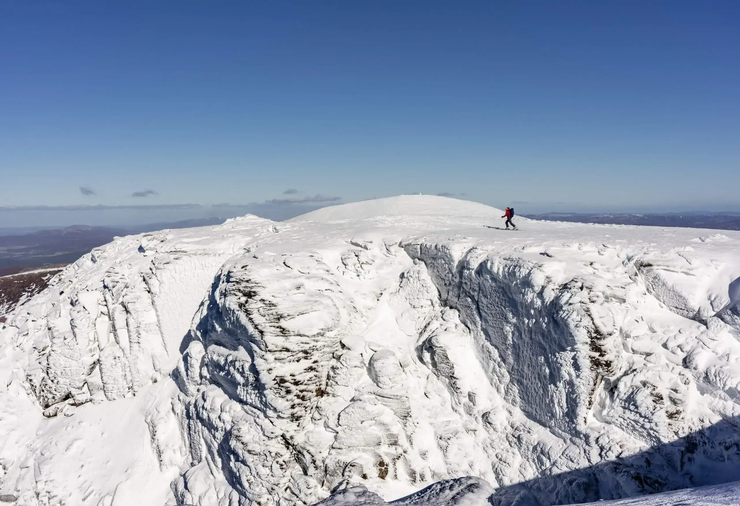 Panoramic view on snow covered mountains and skier on a sunny day, Scotland UK