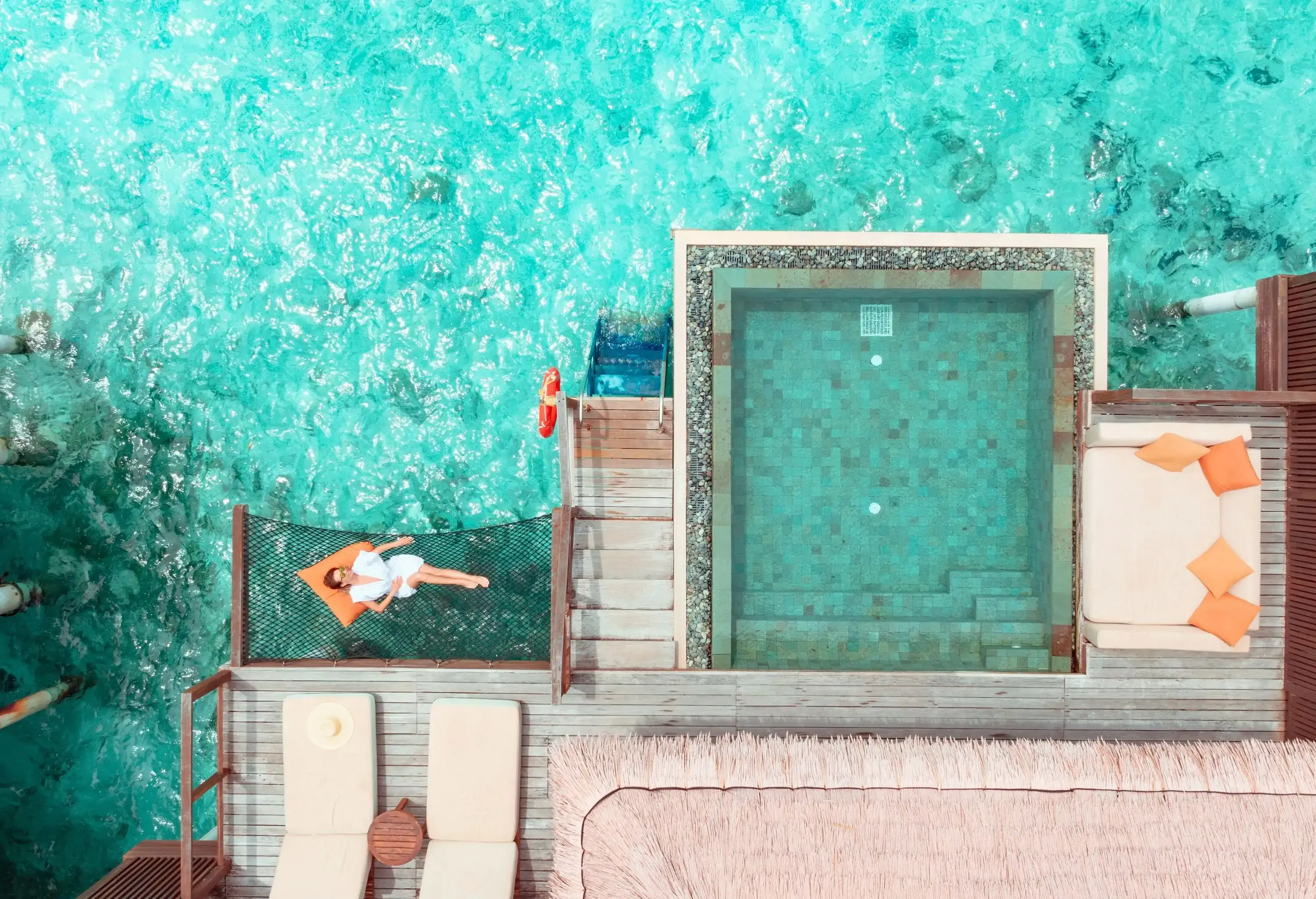Woman lying on hammock over ocean in Maldives
