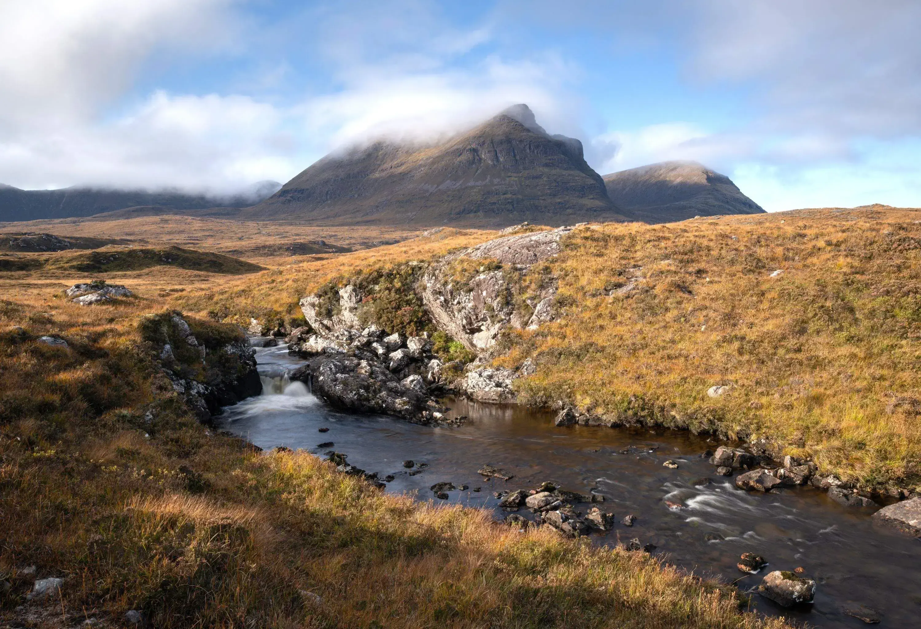 View of a small river in the Highlands with a mountain in the background