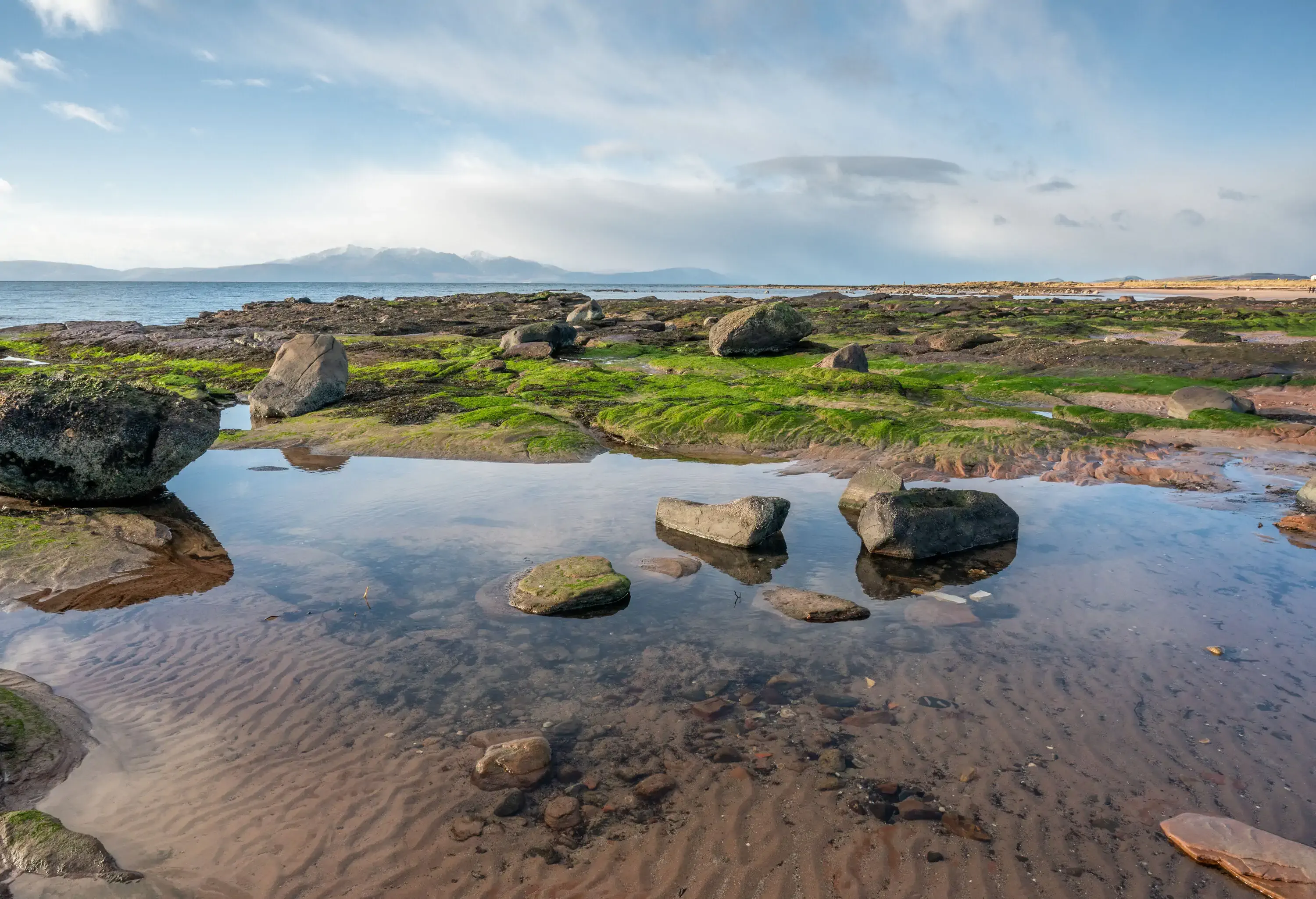 A cold wintery day on the beach at Seamill looking across the Firth of Clyde to the Isle of Arran, the beach is sandy and rocky and ideal for walking or holidays. Seamill village is right on a stretch of several sandy beaches in North Ayrshire overlooking the Isle of Arran. Seamill is named after one of its oldest buildings, the Sea Mill, a grain watermill that appears in 17th Century maps.