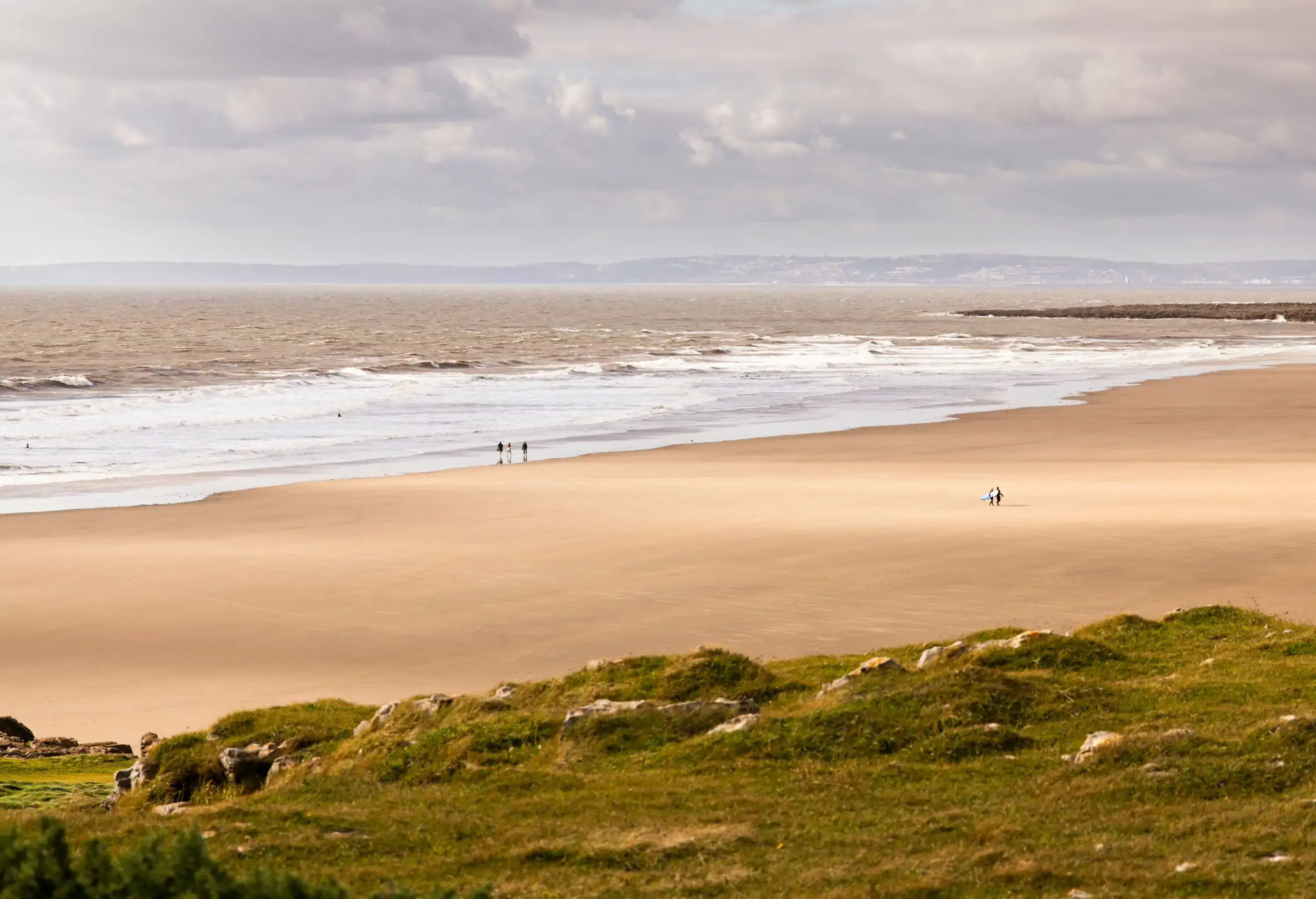 Large sandy beach on a windy day with people in the far background
