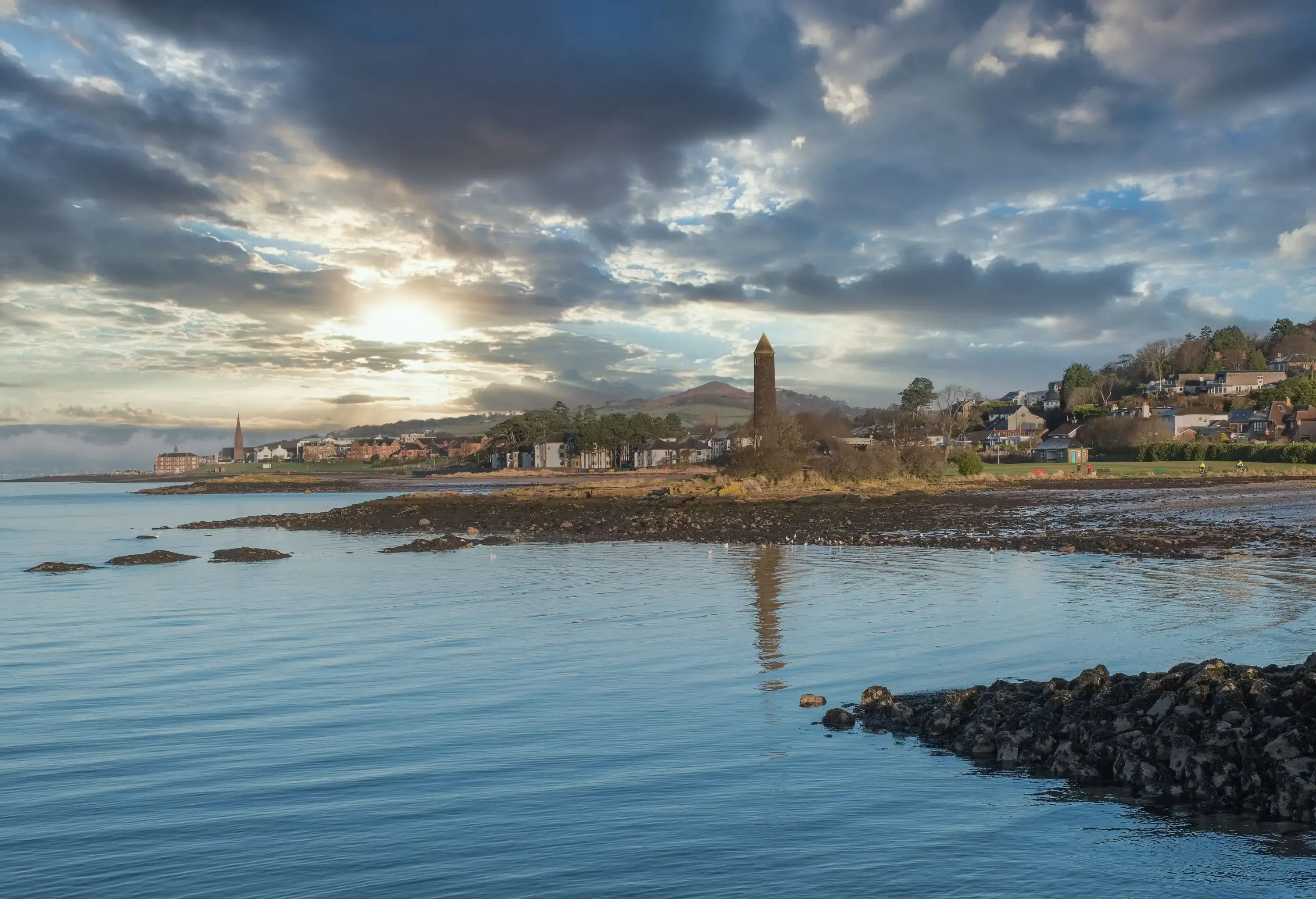Largs foreshore looking past the Pencil Monument on New years Eve with a bitting frost over the town centre which can be seen in the far distance.