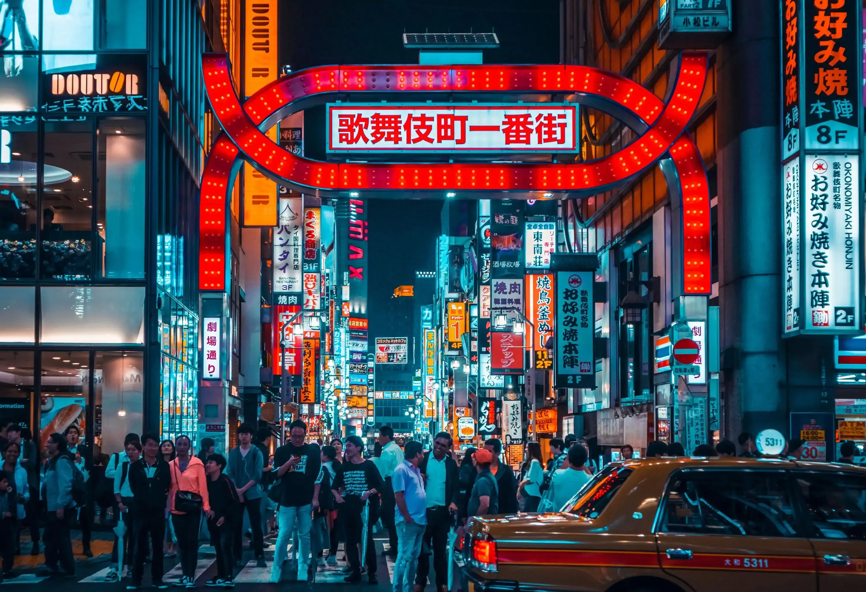 Busy asian city street full of people and neon lights at night