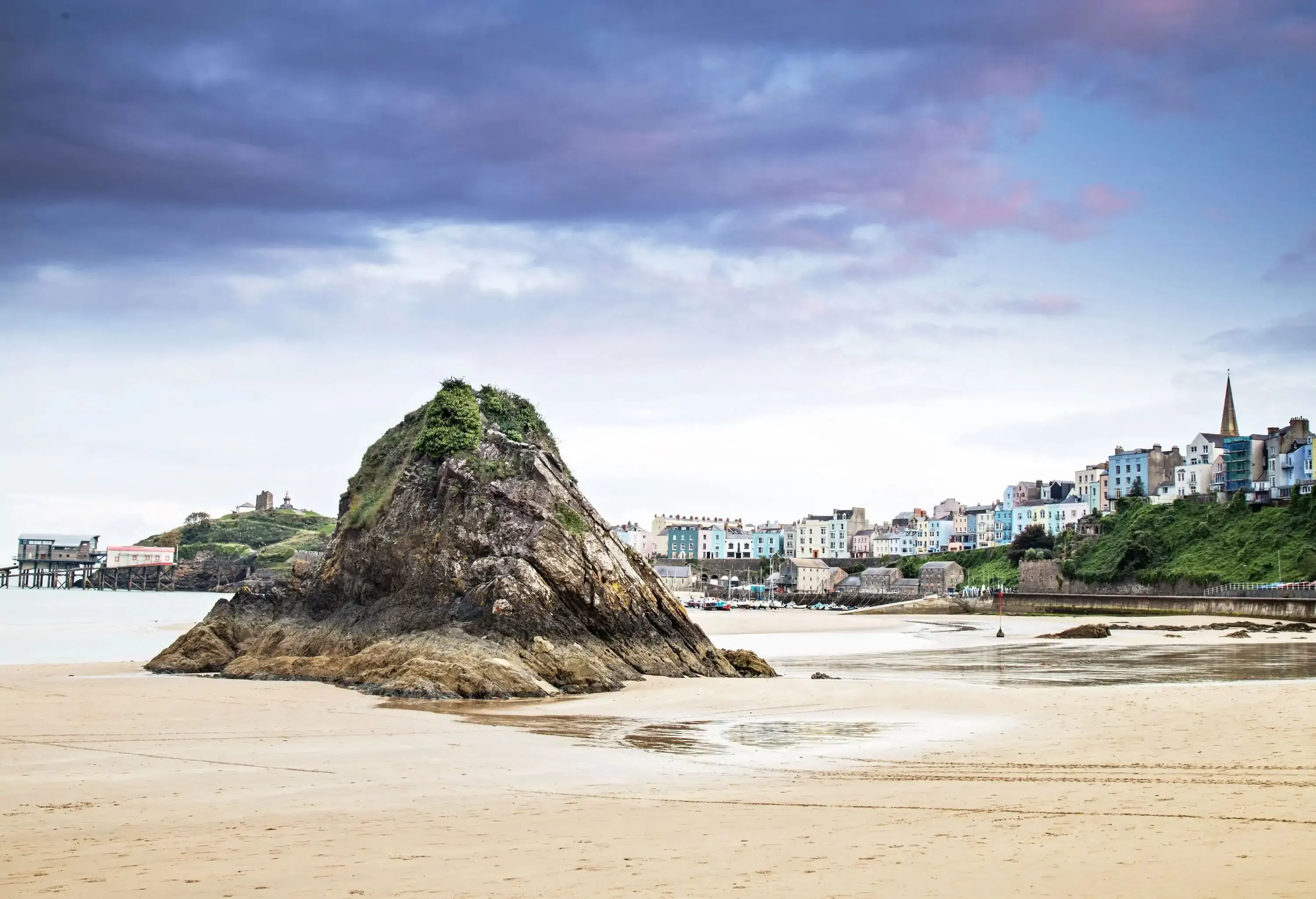 Goskar rock at sunset with iconic colourful terraced houses in background, Tenby, UK