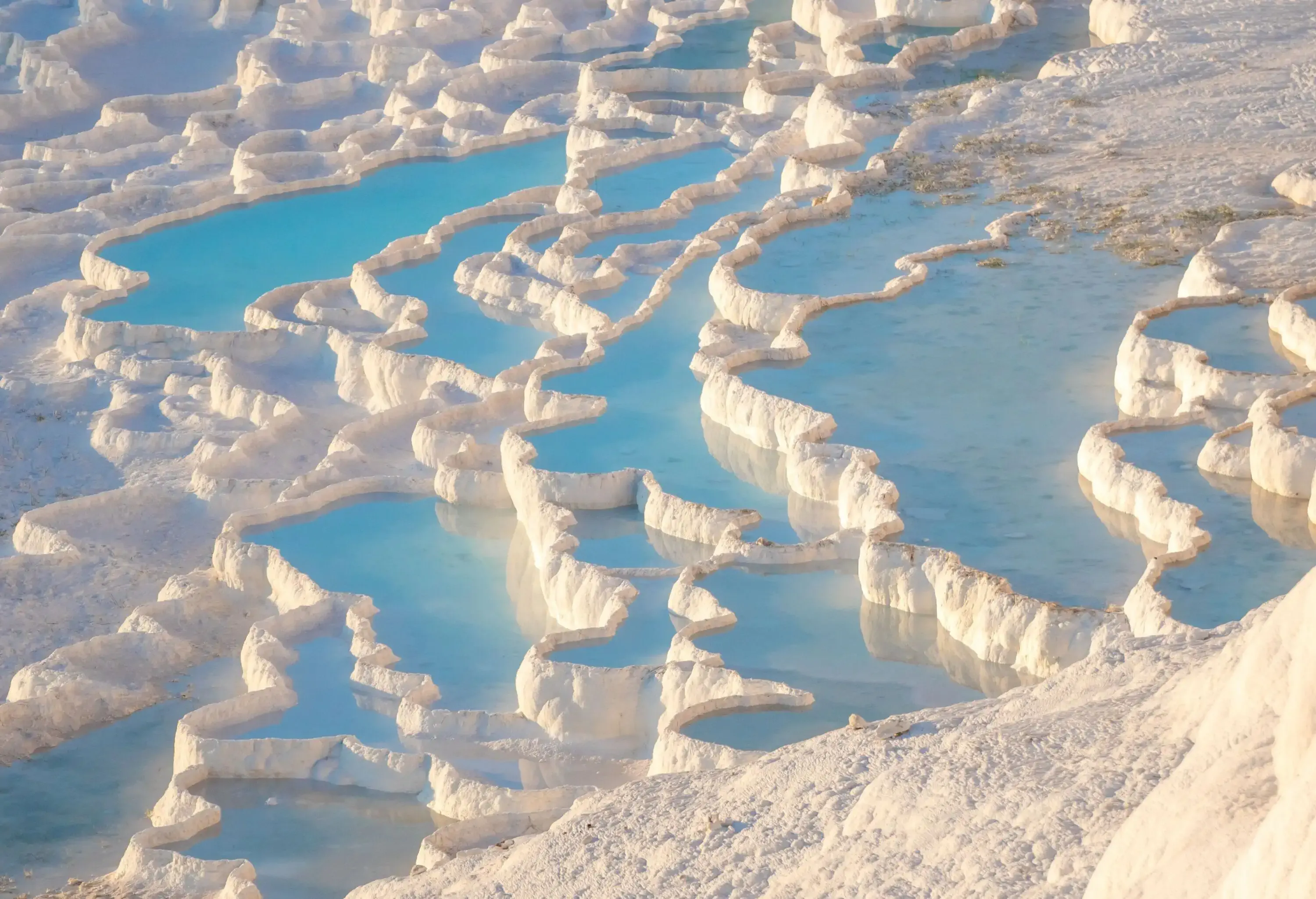 A terrace of natural pools made of white mineral deposits.
