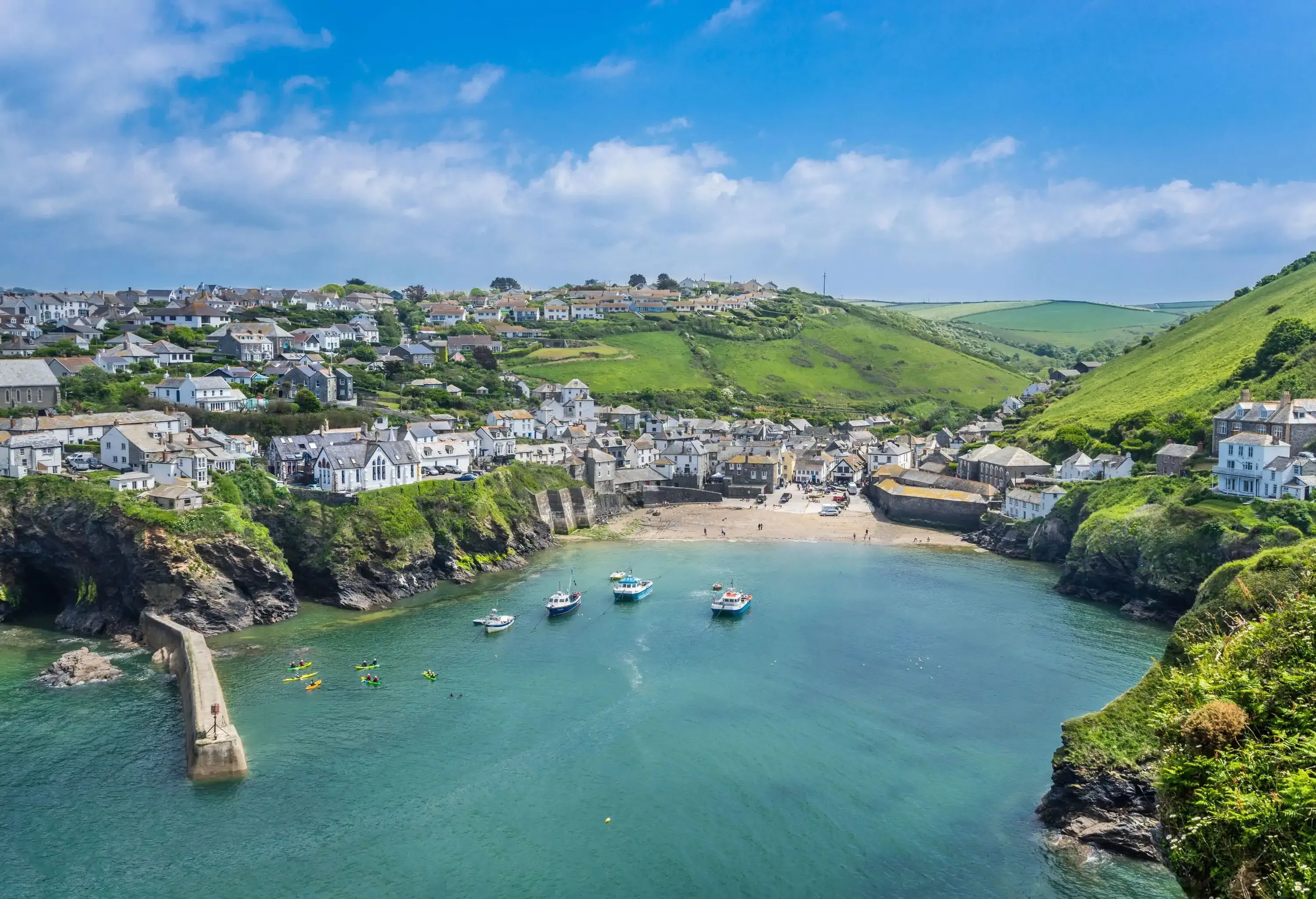Aerial view of harbour and village in a bay surrounded by green hills