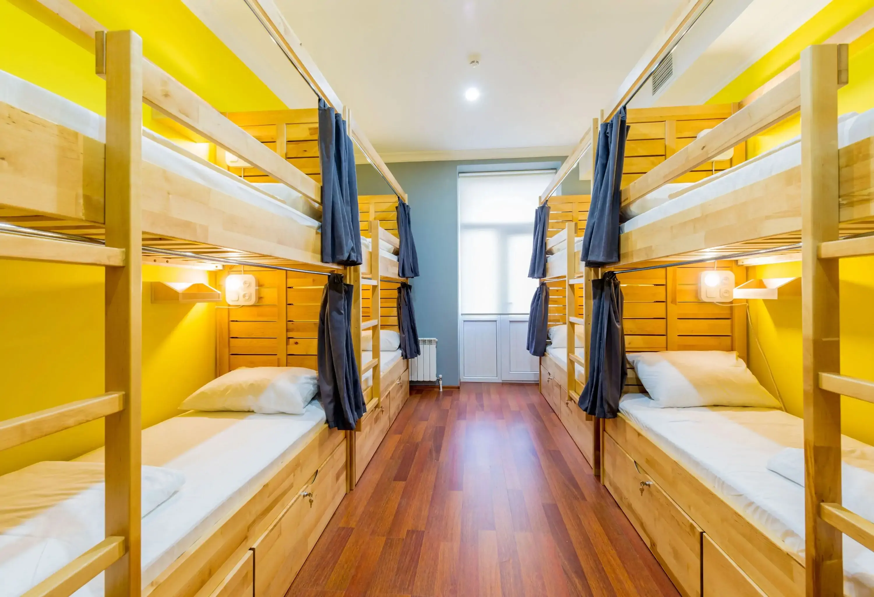 A bright and airy hostel room with wooden bunk beds.