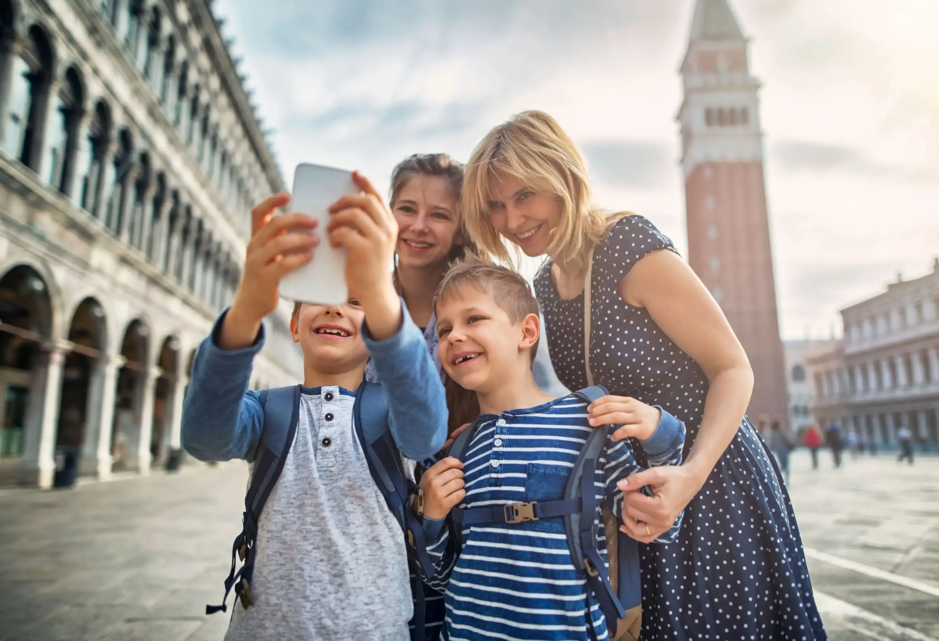 Mother and three children taking selfie in front of historical town church