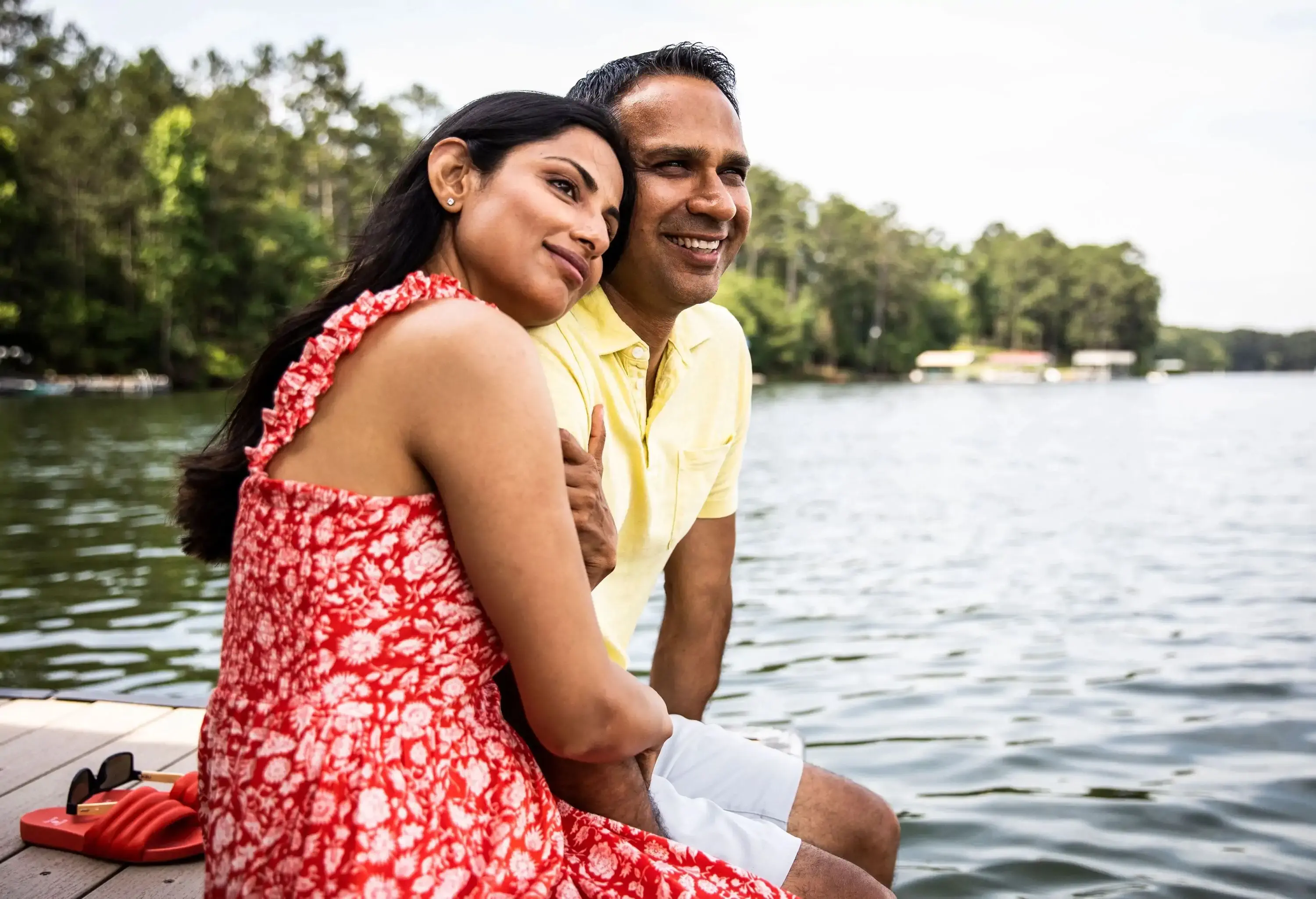 Husband and wife sitting on dock at lake