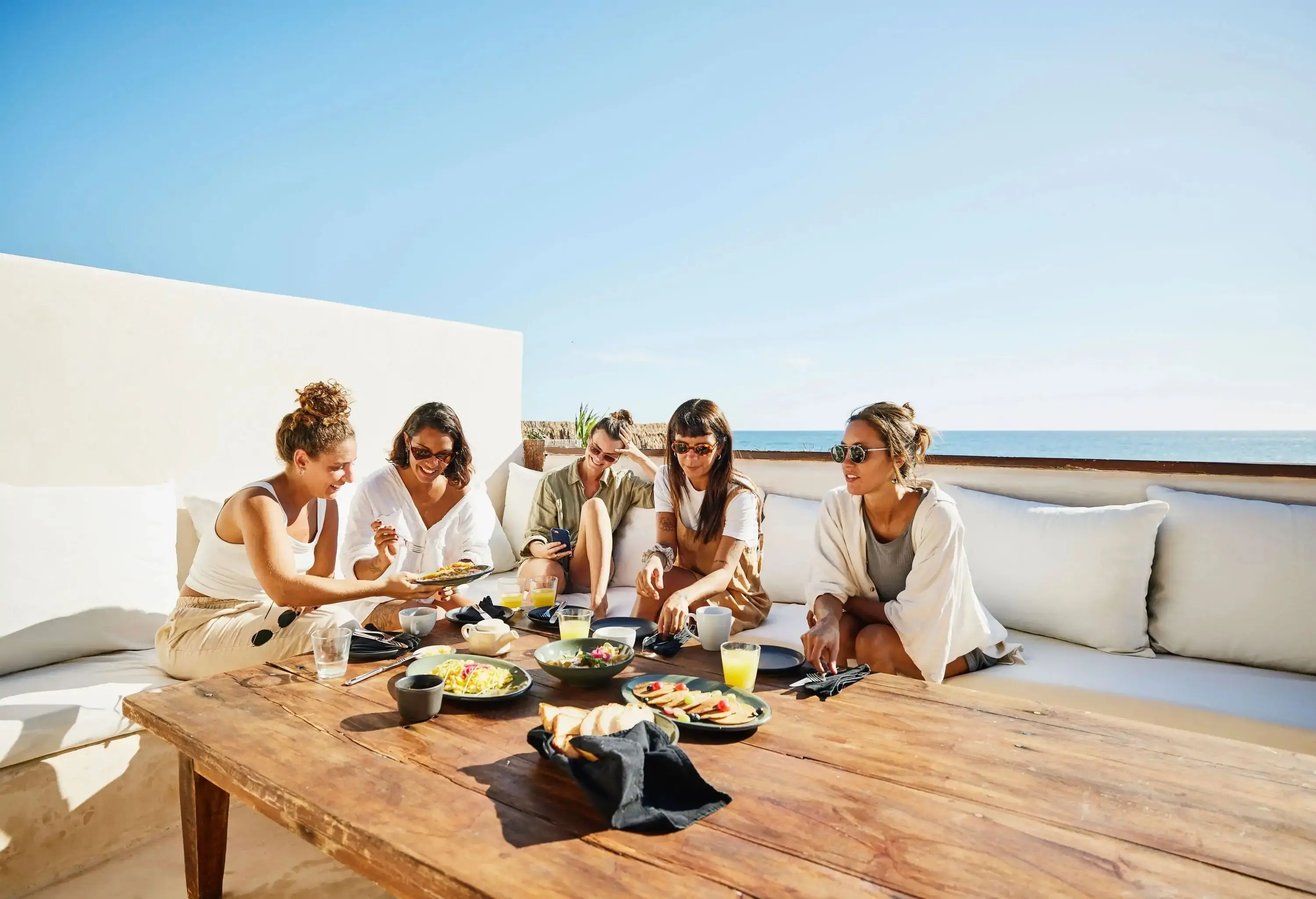 Group of friends enjoying breakfast on the terrace at a holiday resort