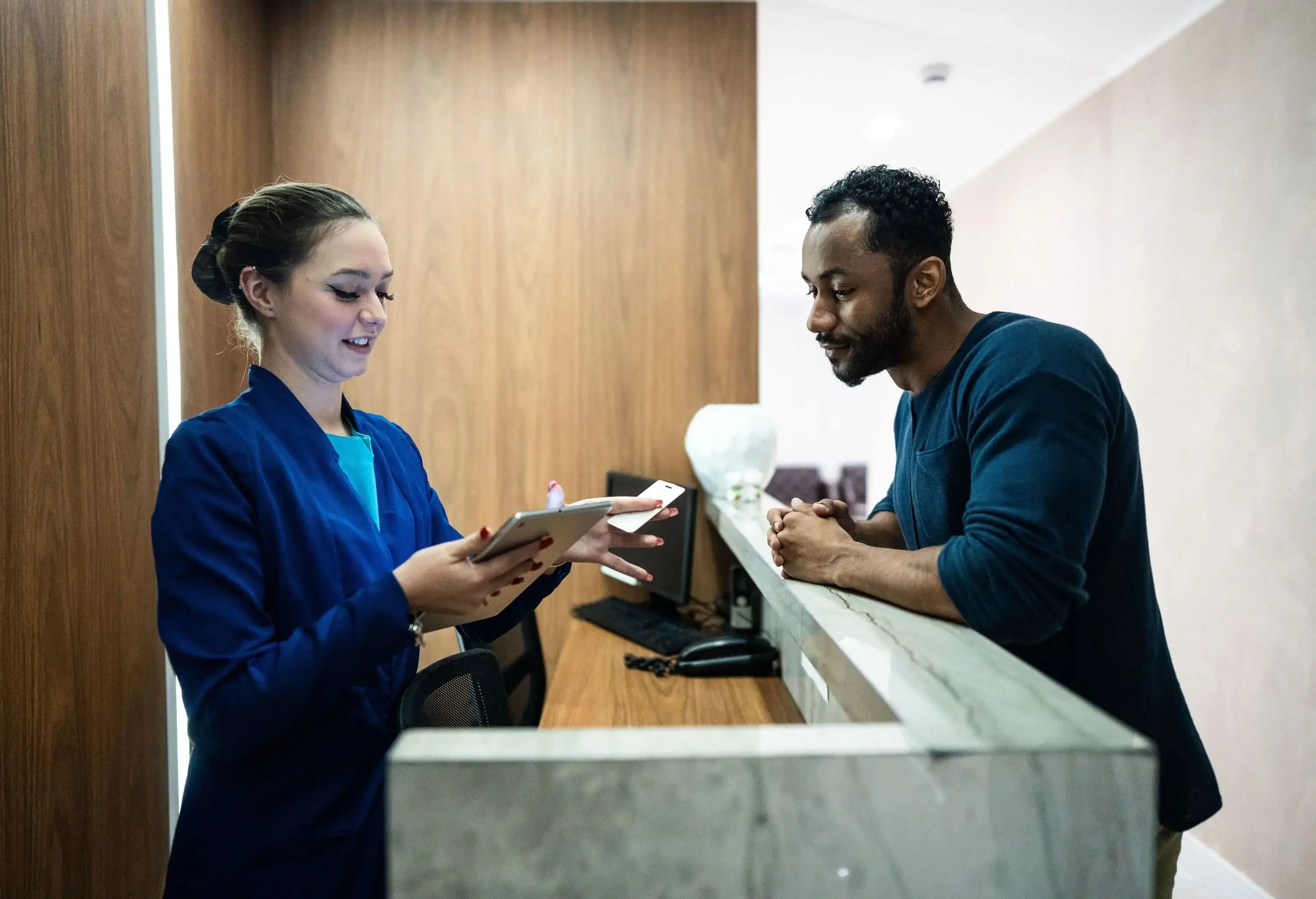 Recepcionist talking to a guest at a hotel lobby