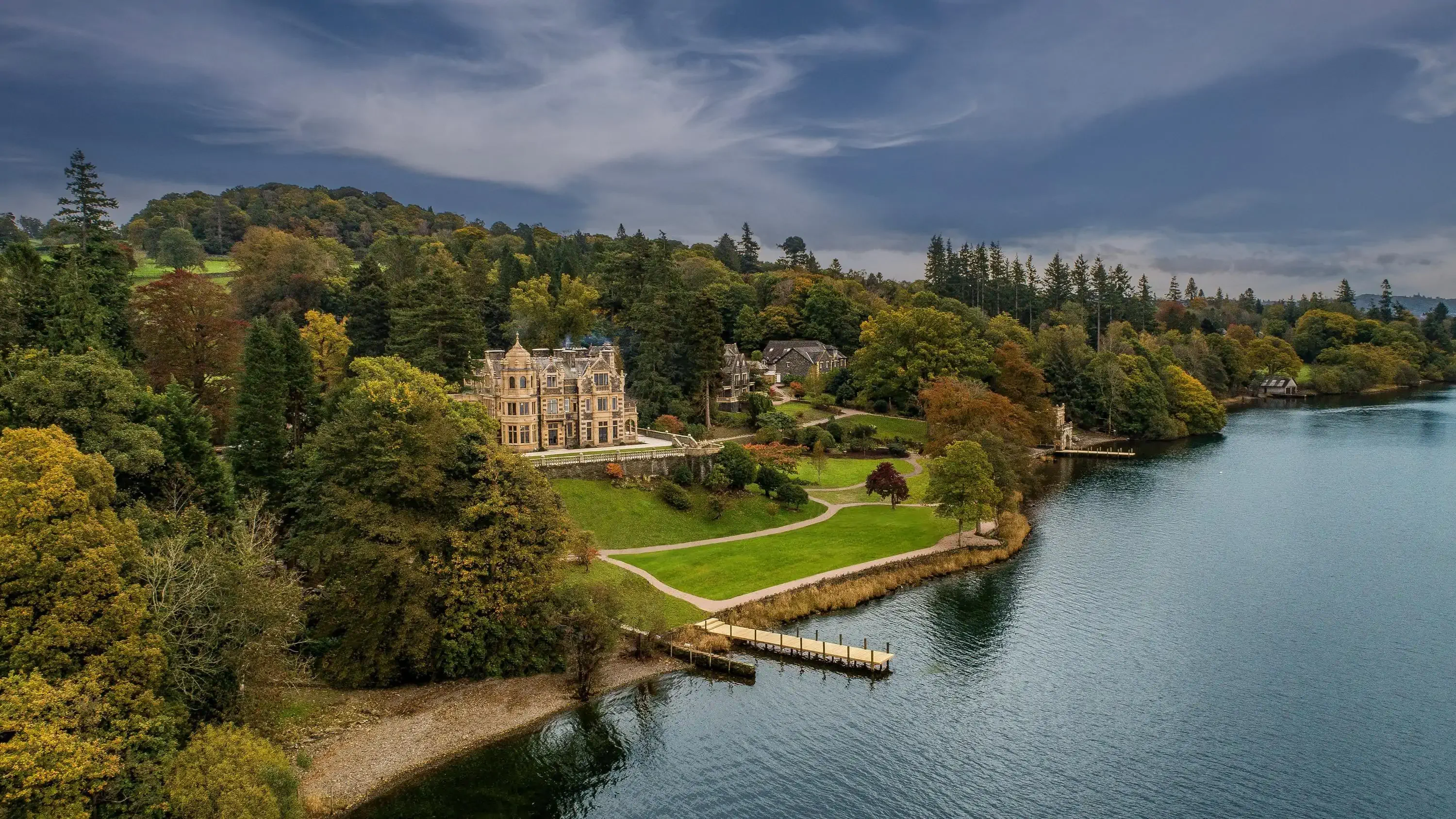 Manor house hotel on a lake surrounded by greenery