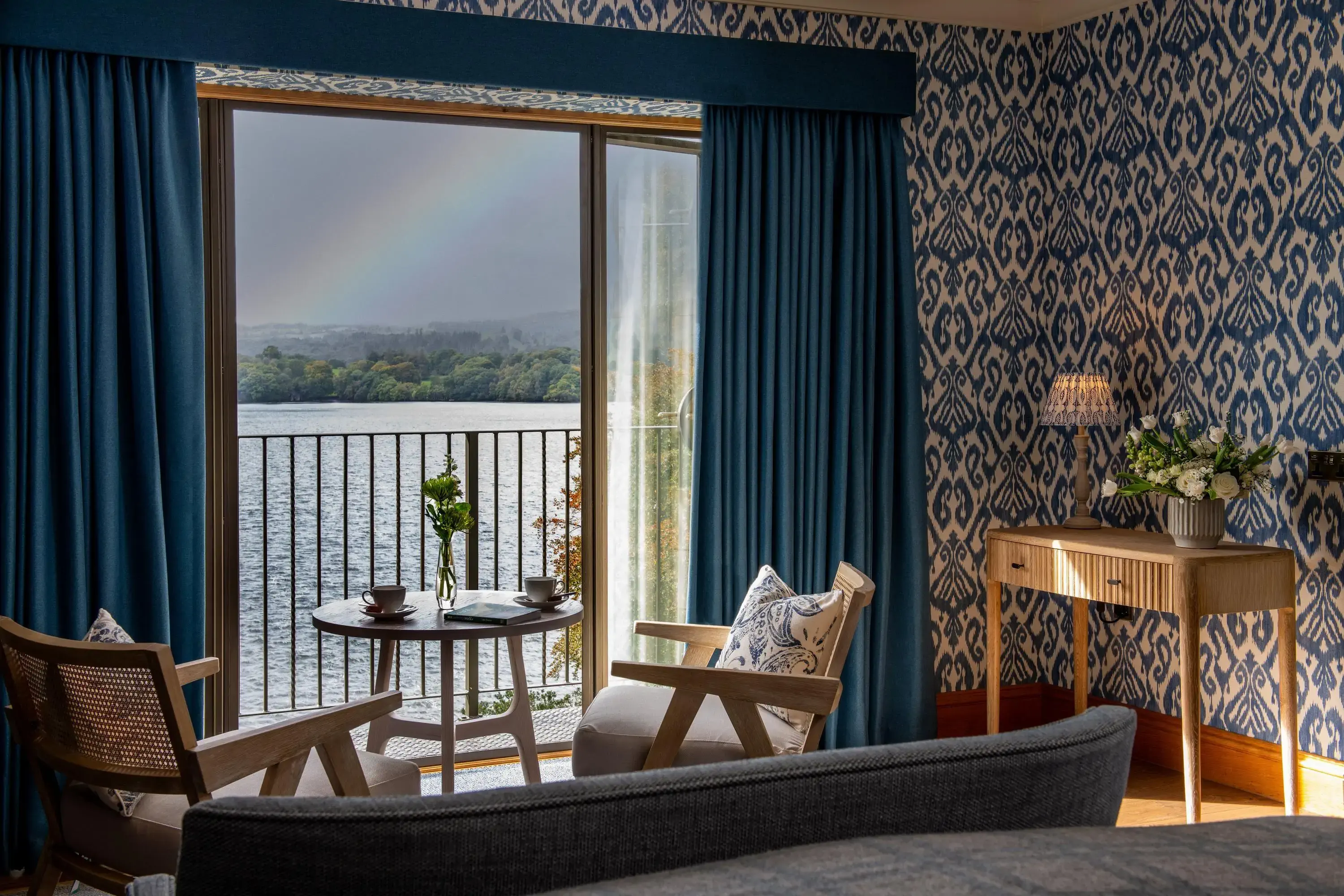 Classic hotel room by a lake with balcony overlooking the water and a rainbow