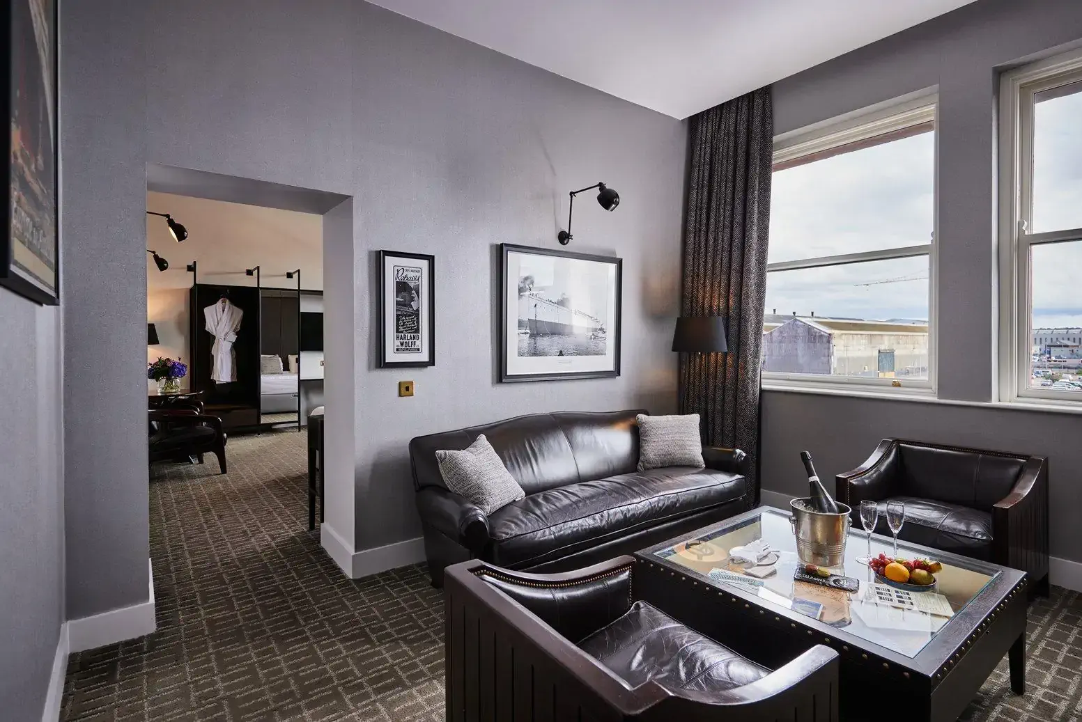 Living room with black leather couches at the Titanic Hotel in Belfast