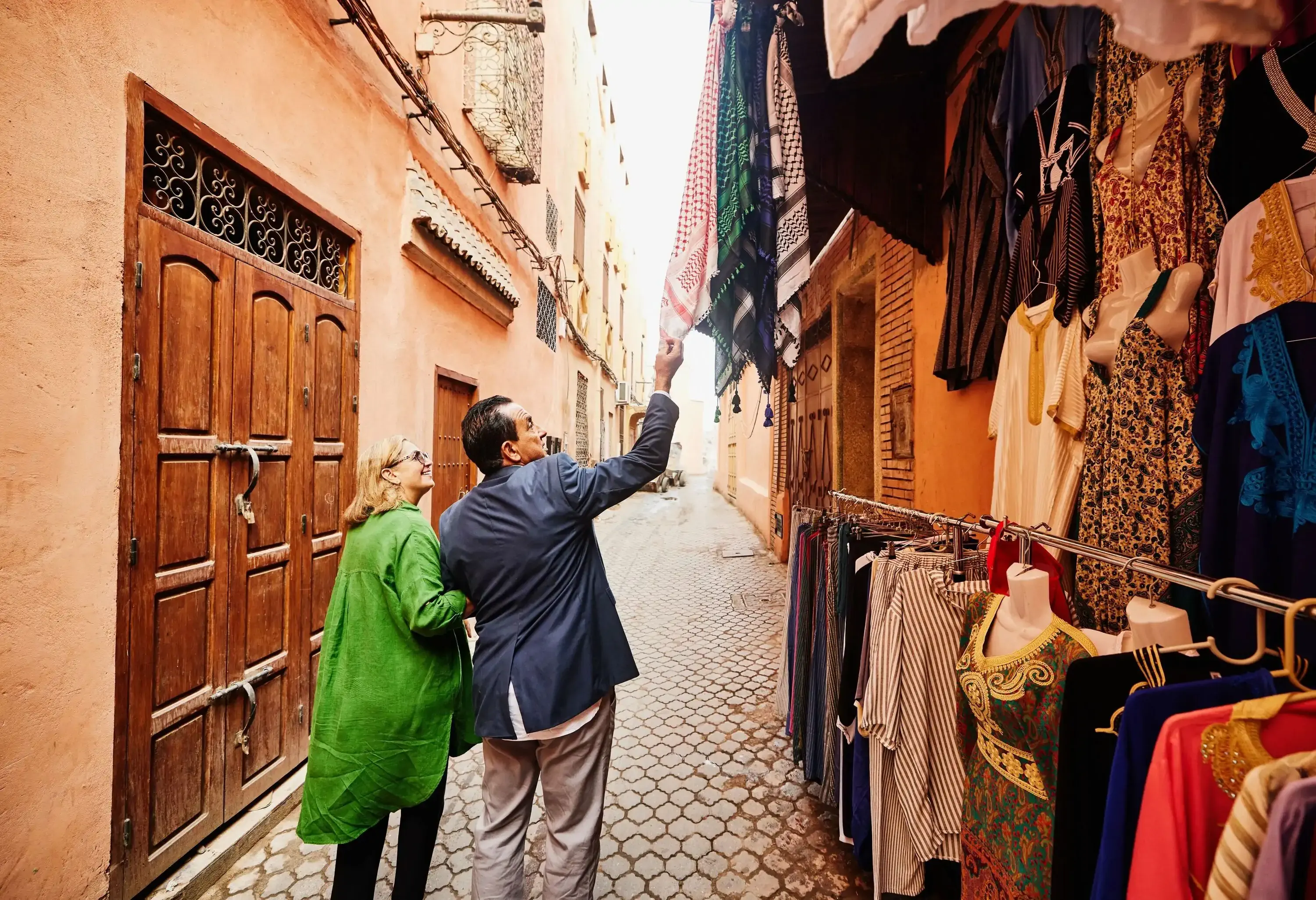 Wide shot of senior couple shopping while exploring the Medina of Marrakech while on vacation