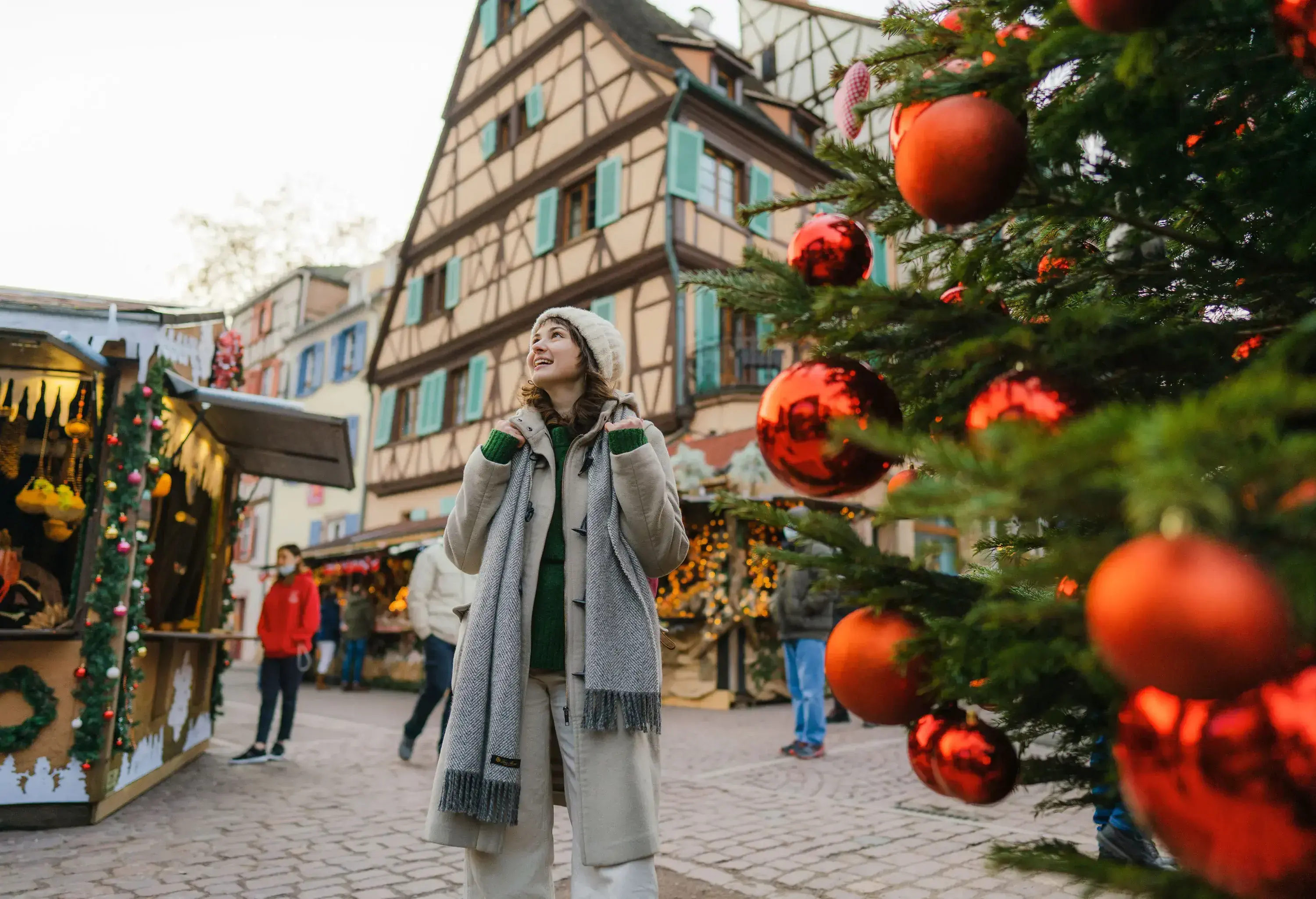 Young Caucasian woman walking near the Christmas tree in city centre