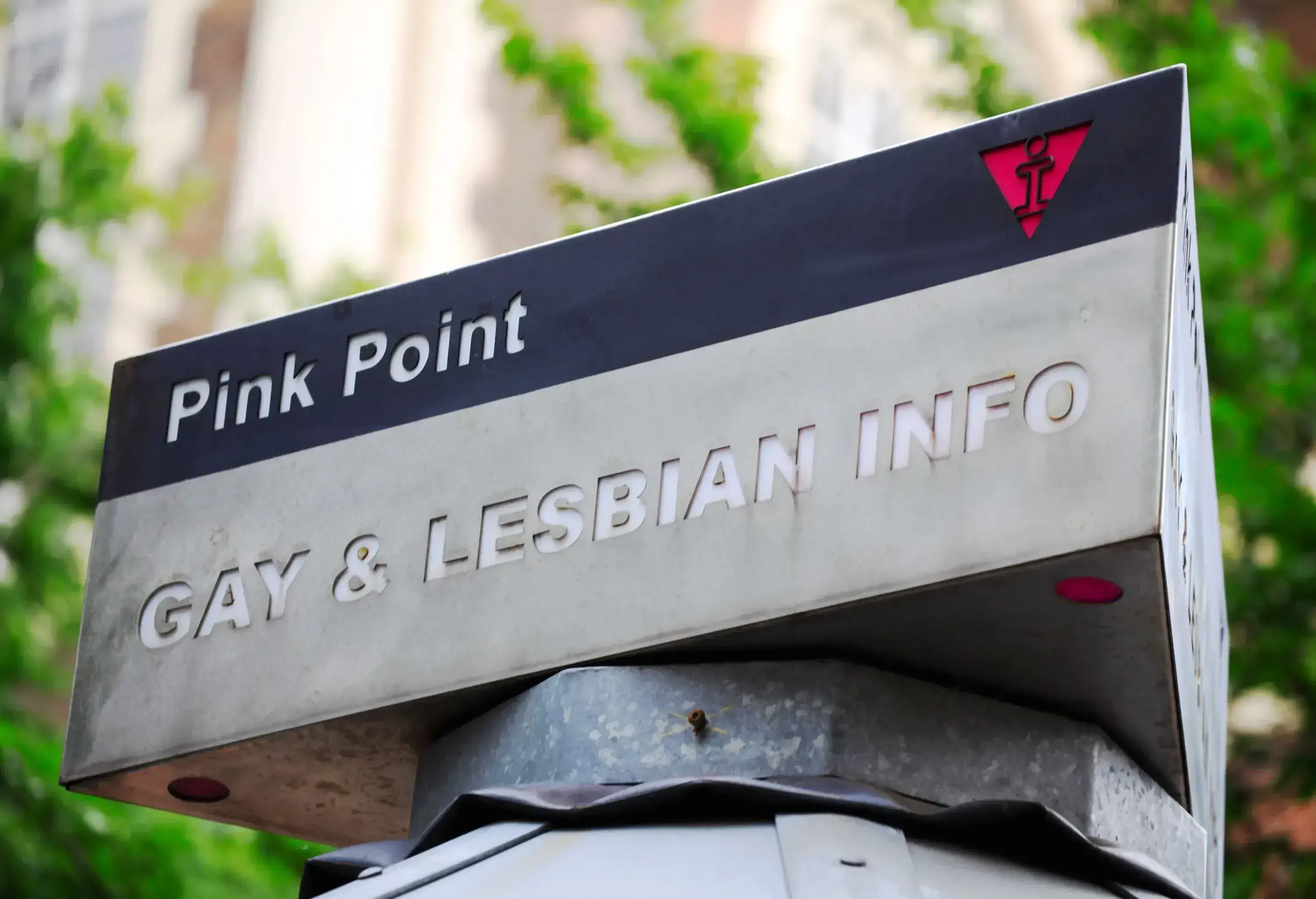 A pink point signage, a gay and lesbian information kiosk.