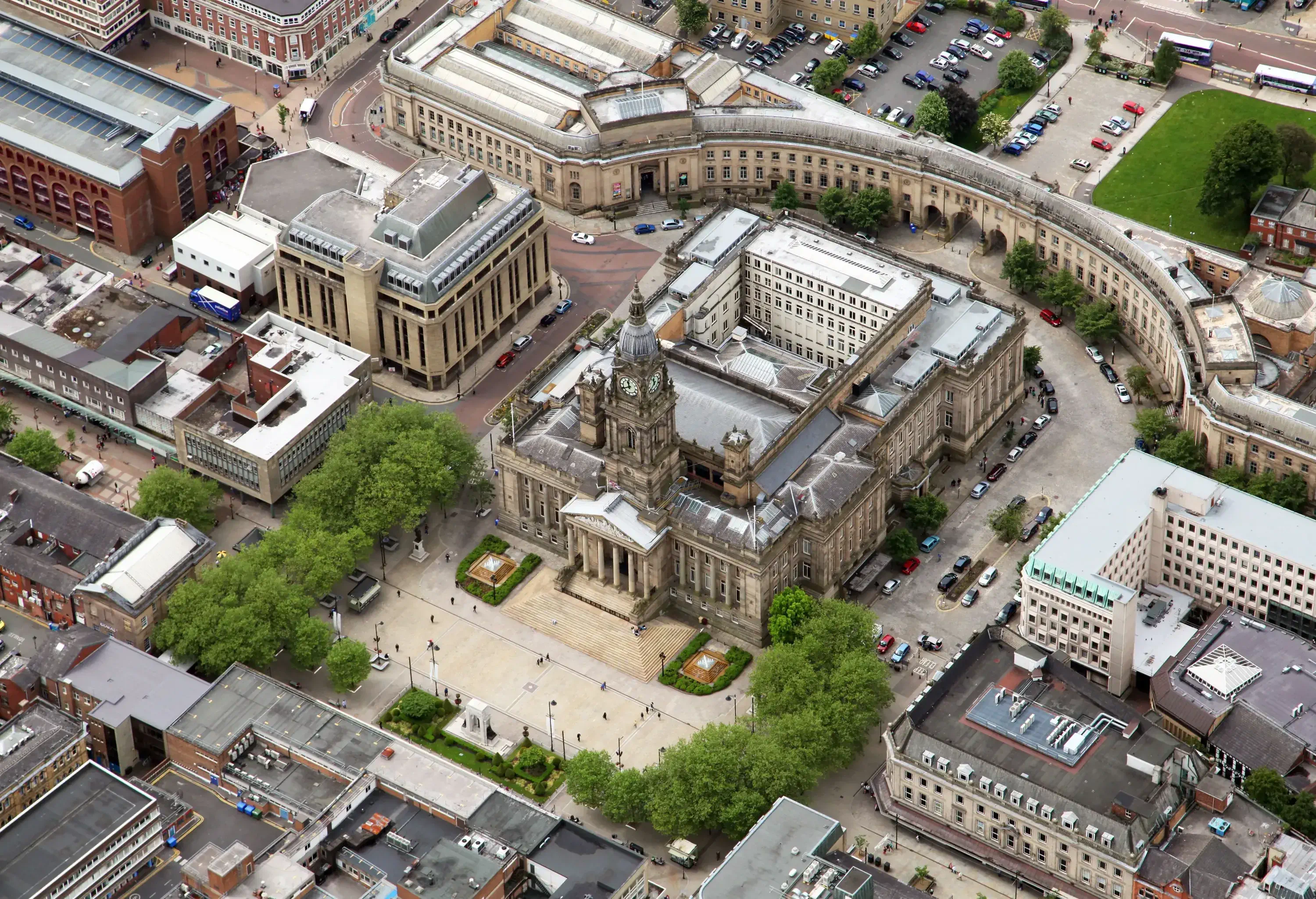 Bolton Town Hall is a neoclassical building with a clock tower in front of a town square.