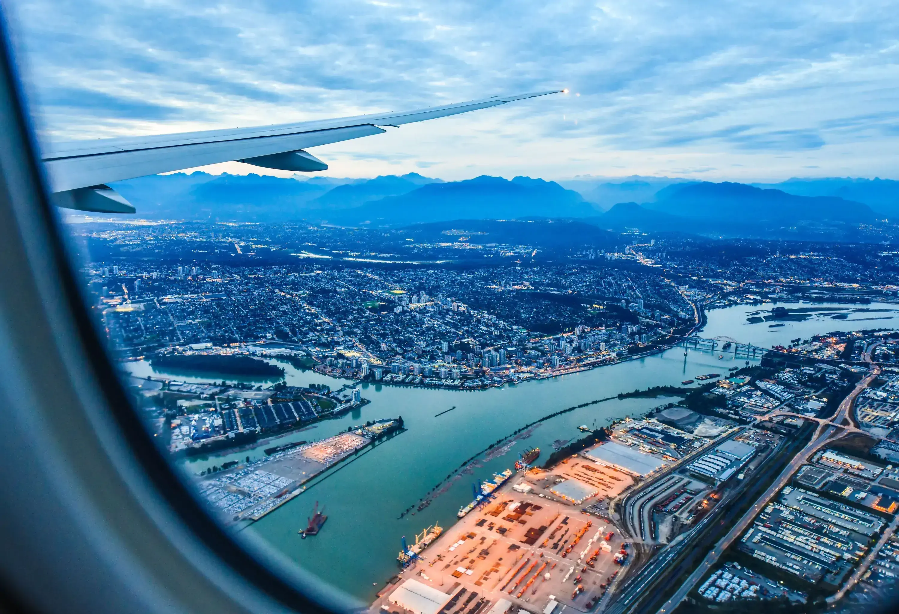 A captivating view from an airplane window reveals a sprawling cityscape with a meandering river.
