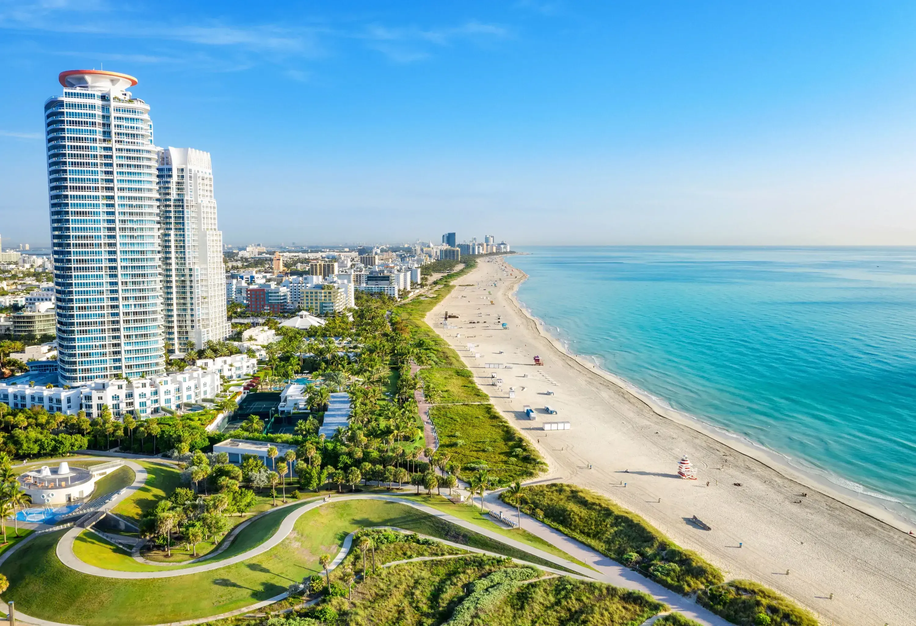 An extensive stretch of sandy beach bordered by towering hotels with ocean views.