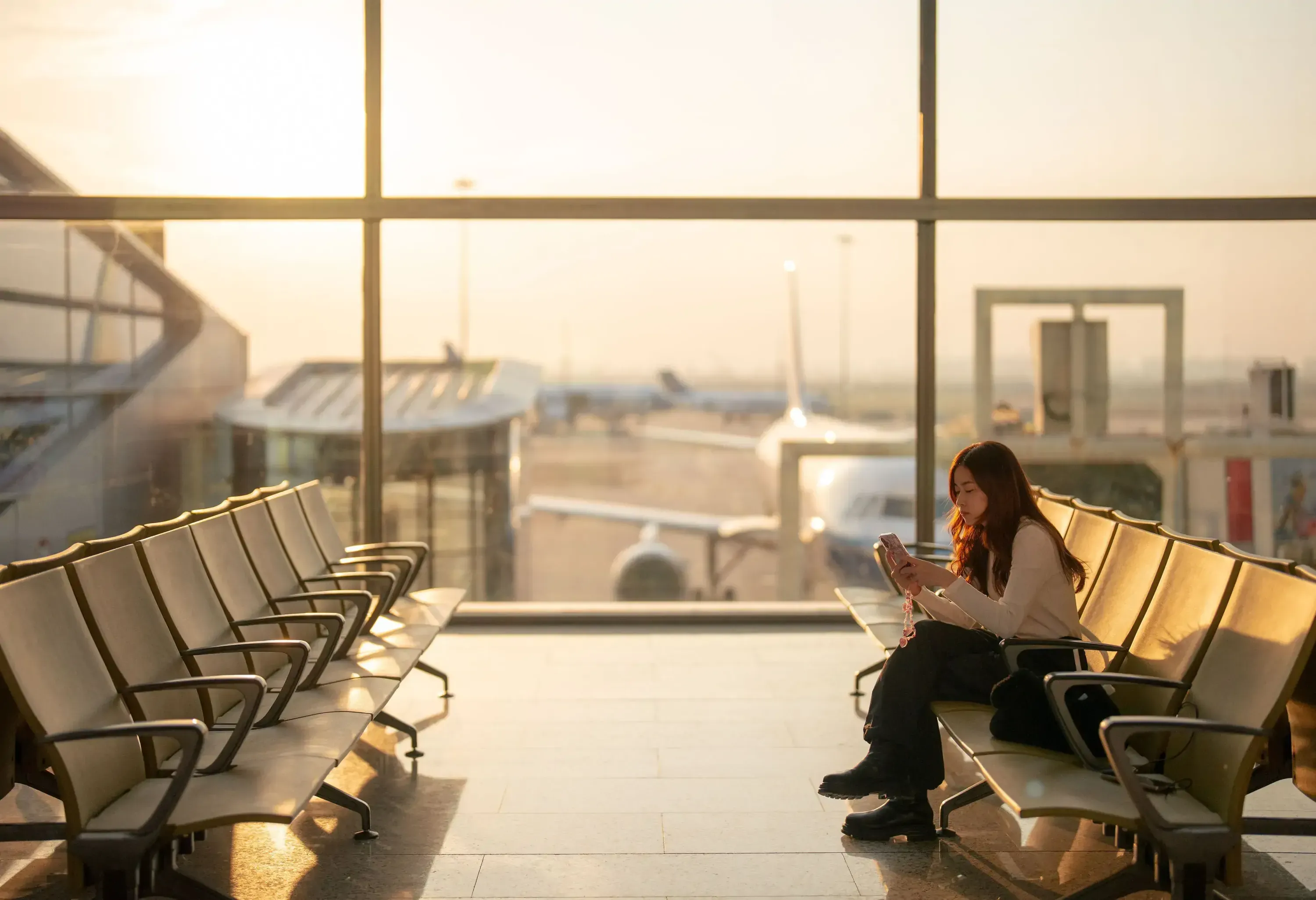 A women sitting alone in an empty airport hall waiting for depart