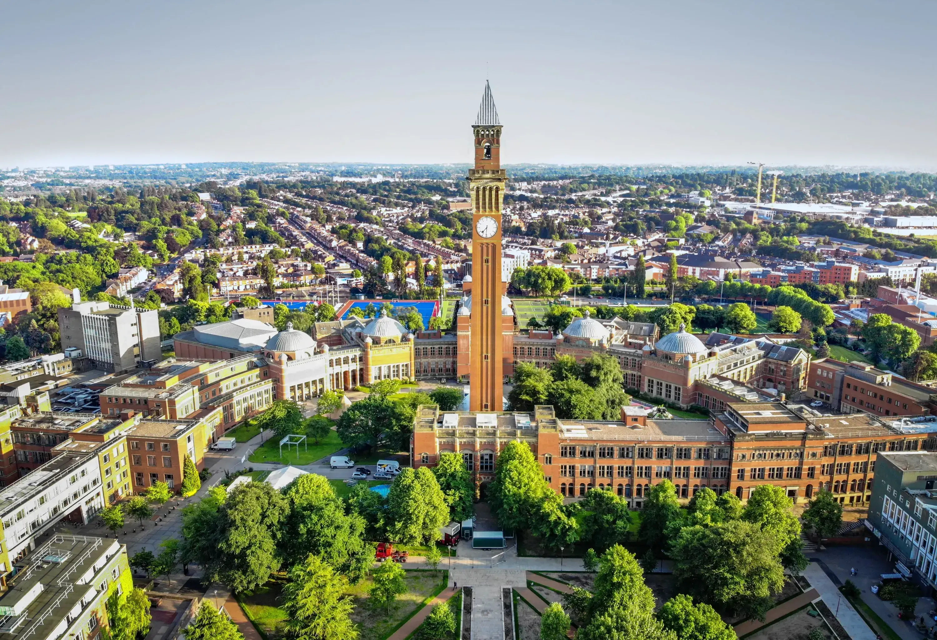 A clock tower surrounded by buildings in the middle of a highly urbanized city.