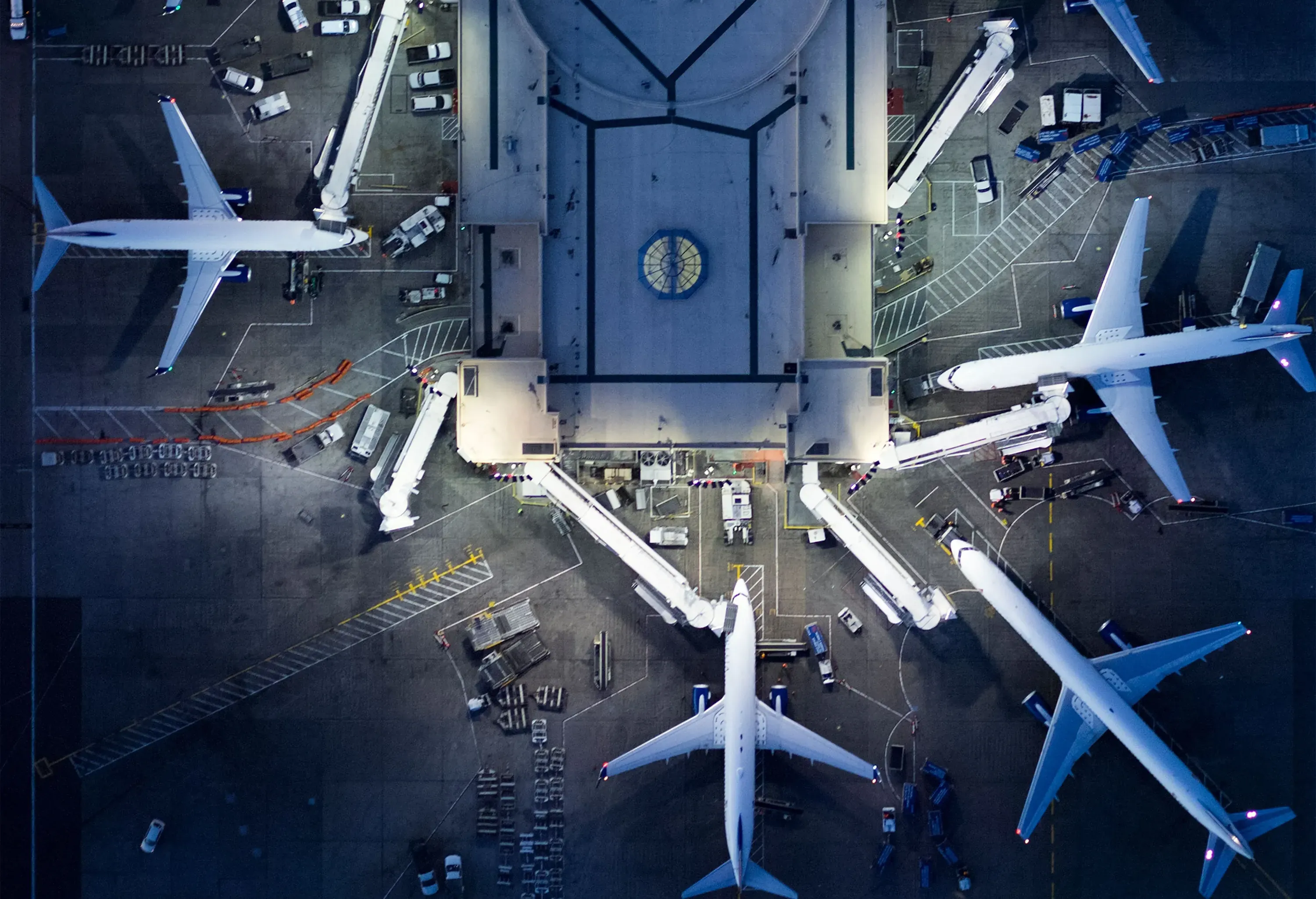 An airport terminal with a busy runway full of airplanes connected to skybridges.